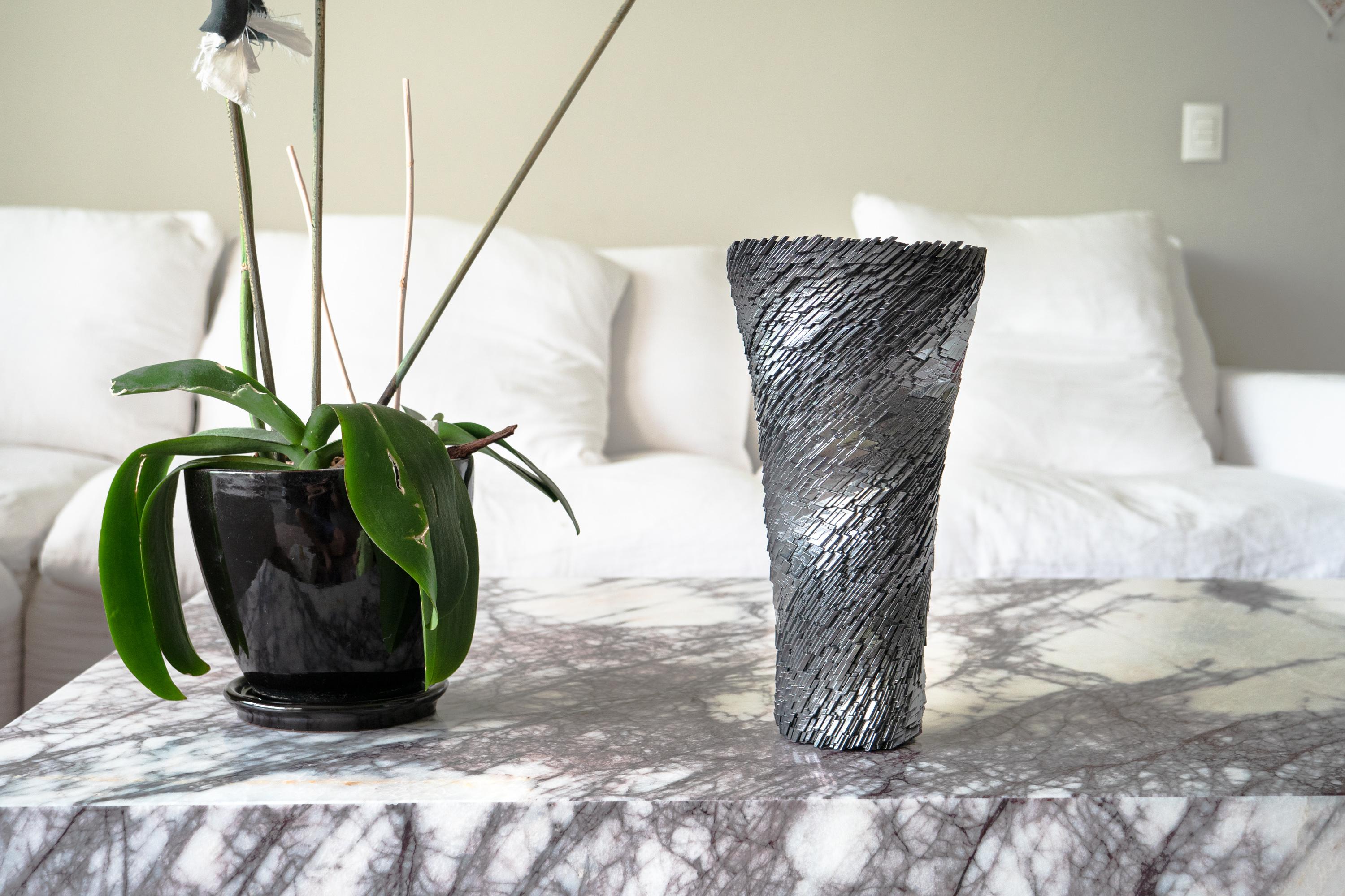 A unique geometric vase showcasing the procedural design Katz Studio is known for.

Additive manufacturing resin finished with graphite for a unique dark chrome reflective finish.

For decorative purposes only, finish will degrade with prolonged