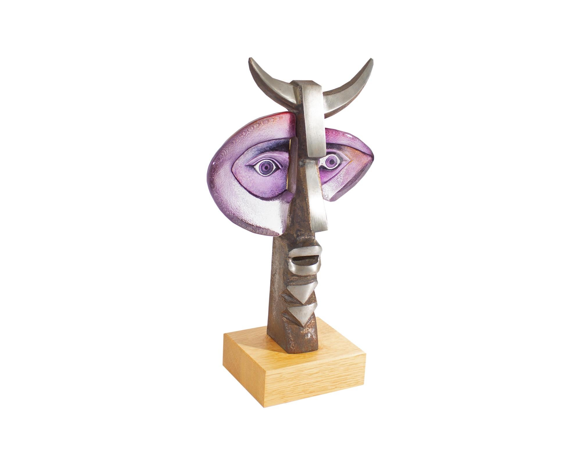 A 2006 limited edition sculpture by the Swedish glass artist and designer Mats Jonasson (born 1945). Produced by Målerås Glasbruk, this sculpture depicts an abstract faun with purple asymmetrical glass face and eyes and a metal mouth and horns. The