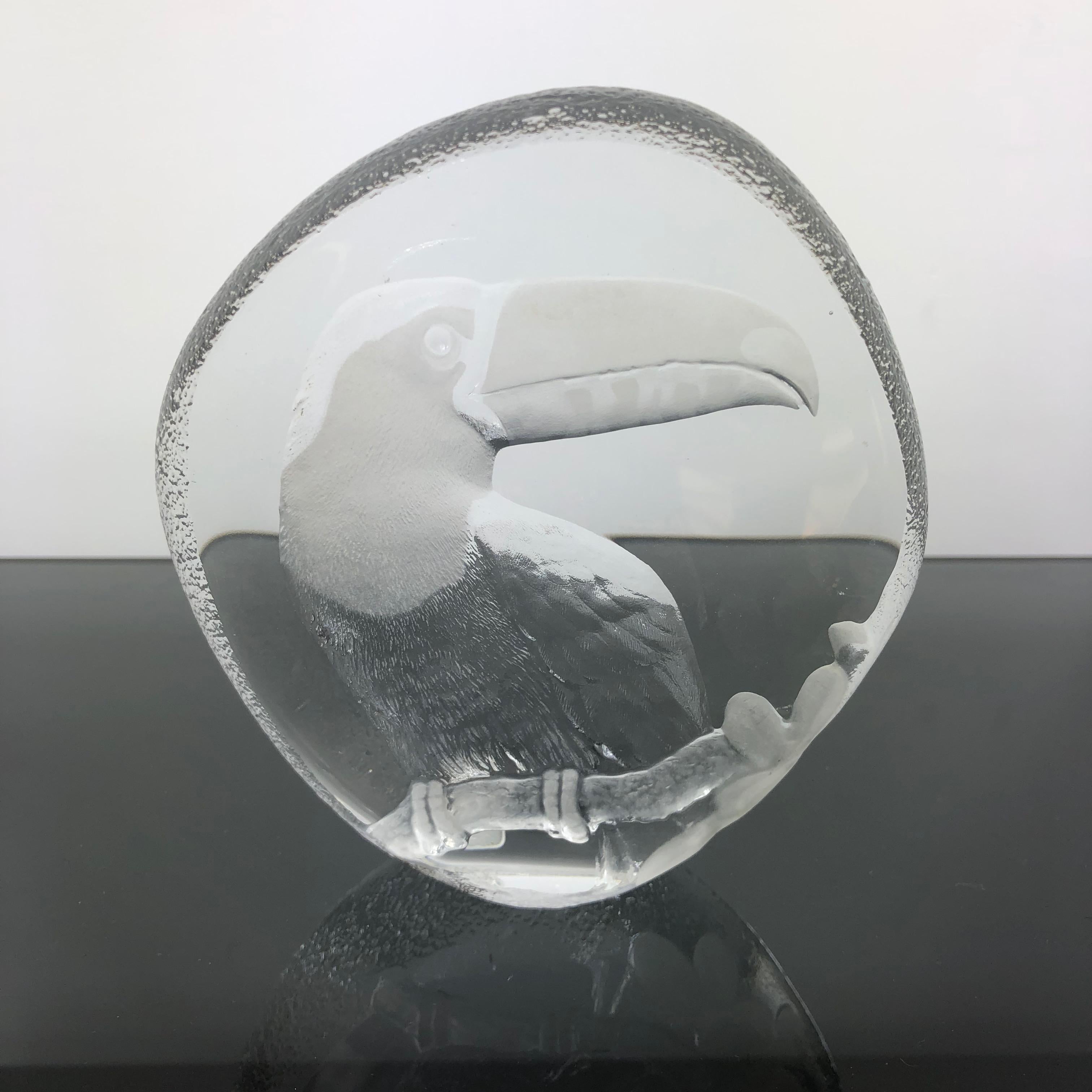 A lead crystal glass paperweight, produced circa 1980s by Mats Jonasson of Sweden, designed as a seal, with frosted detail in the shape of a toucan. Markings include signature [Mats Jonasson, Sweden] and serial number to the base next to the