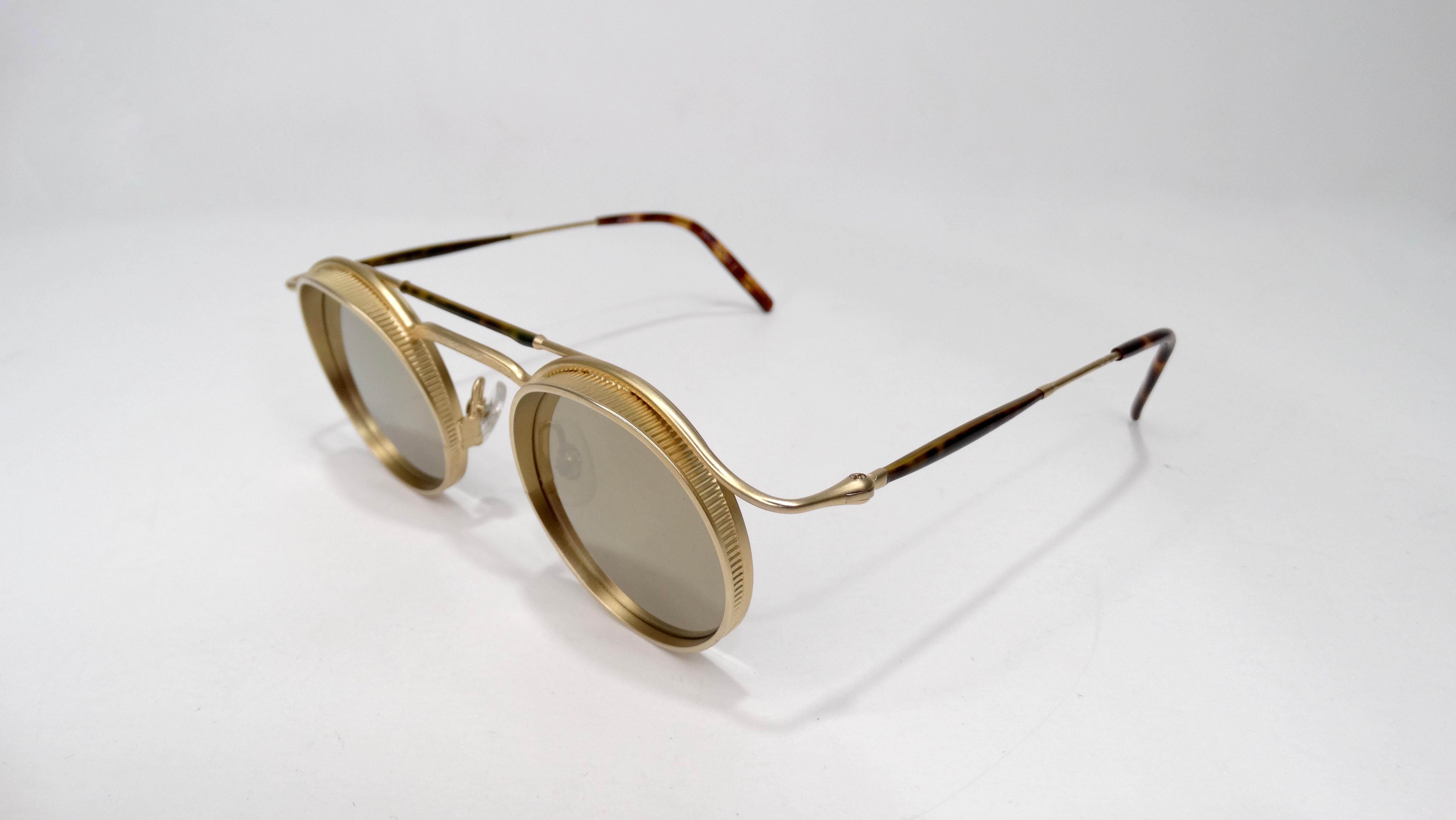 Elevate your sunglasses games with these amazing Matsuda's! Circa 1990s, these steampunk style sunglasses feature a round brushed antique gold frame with inlayed mirrored lenses. Timeless with an edge, these sunglasses look great on both males and