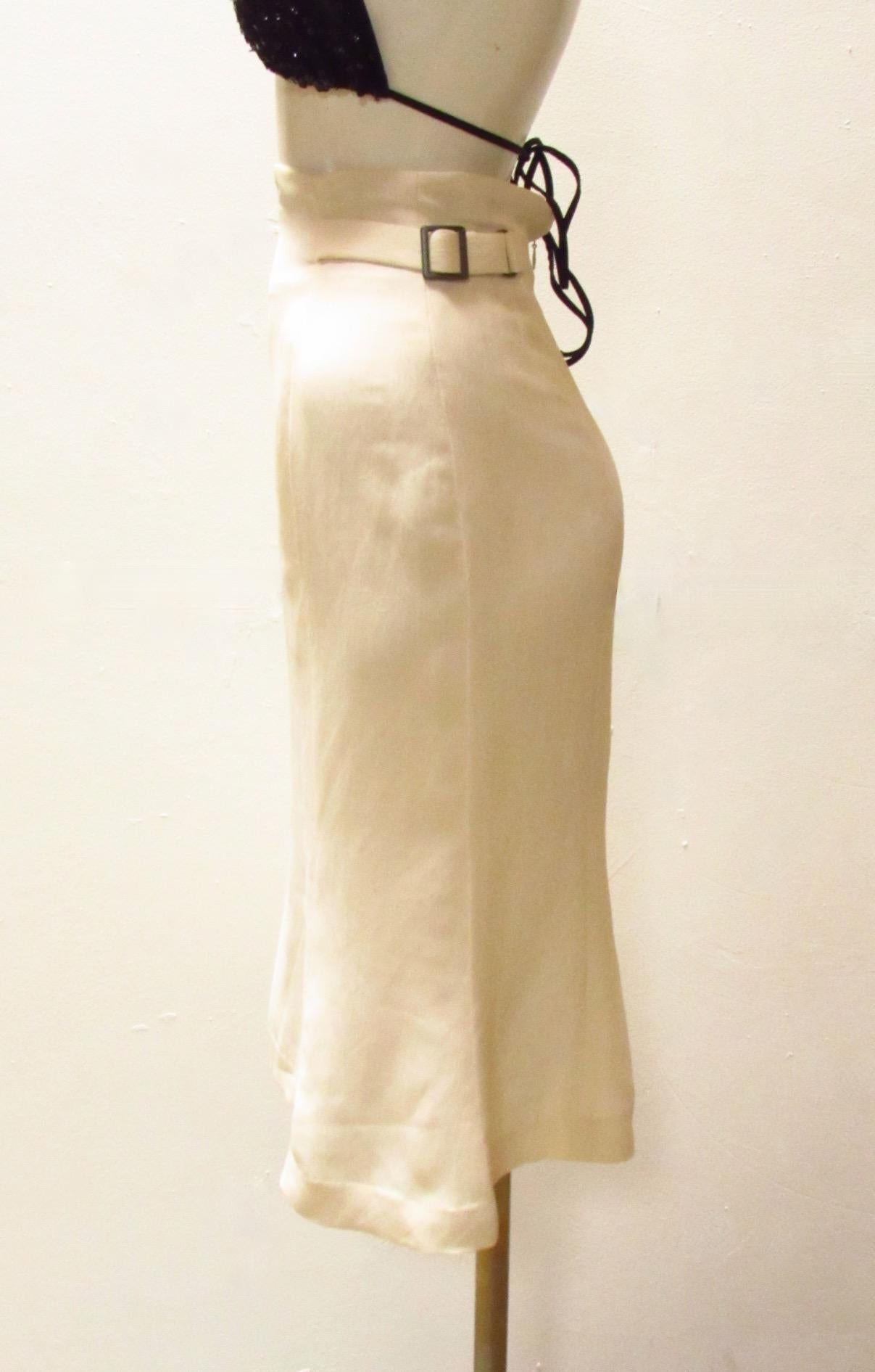 A cream colored rayon and linen high-waisted skirt from Matsuda. With a back zipper and side buckles, the waist can be cinched for a perfect fit. The mid-length skirt falls to a feminine tulip shape. 