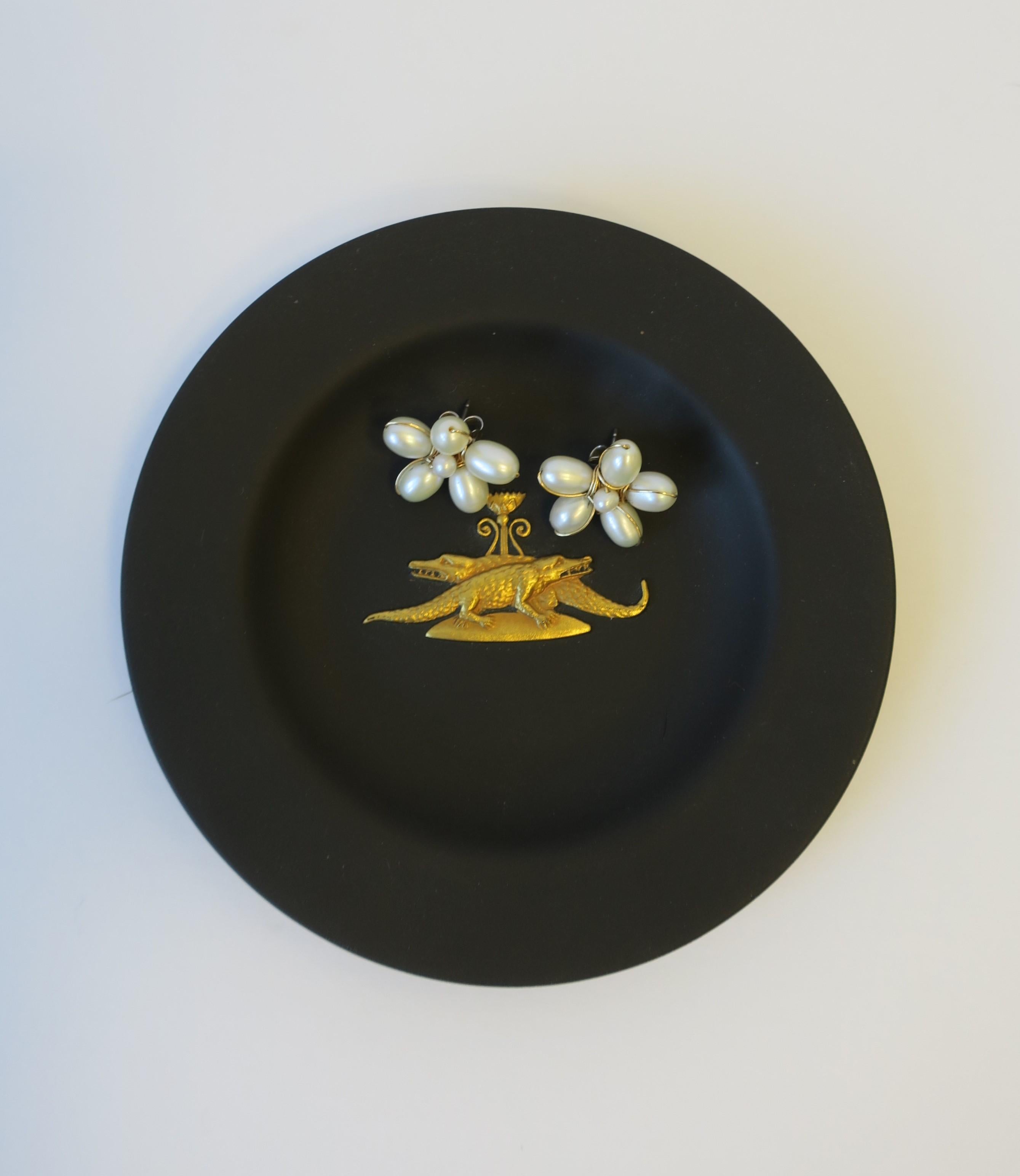 A chic and rare English Jasperware matte black basalt and gold dish by Wedgwood, England. A very beautiful small dish, with a gold raised relief of two alligators or crocodiles. Dish is beautiful as a standalone piece, or for small jewelry or other