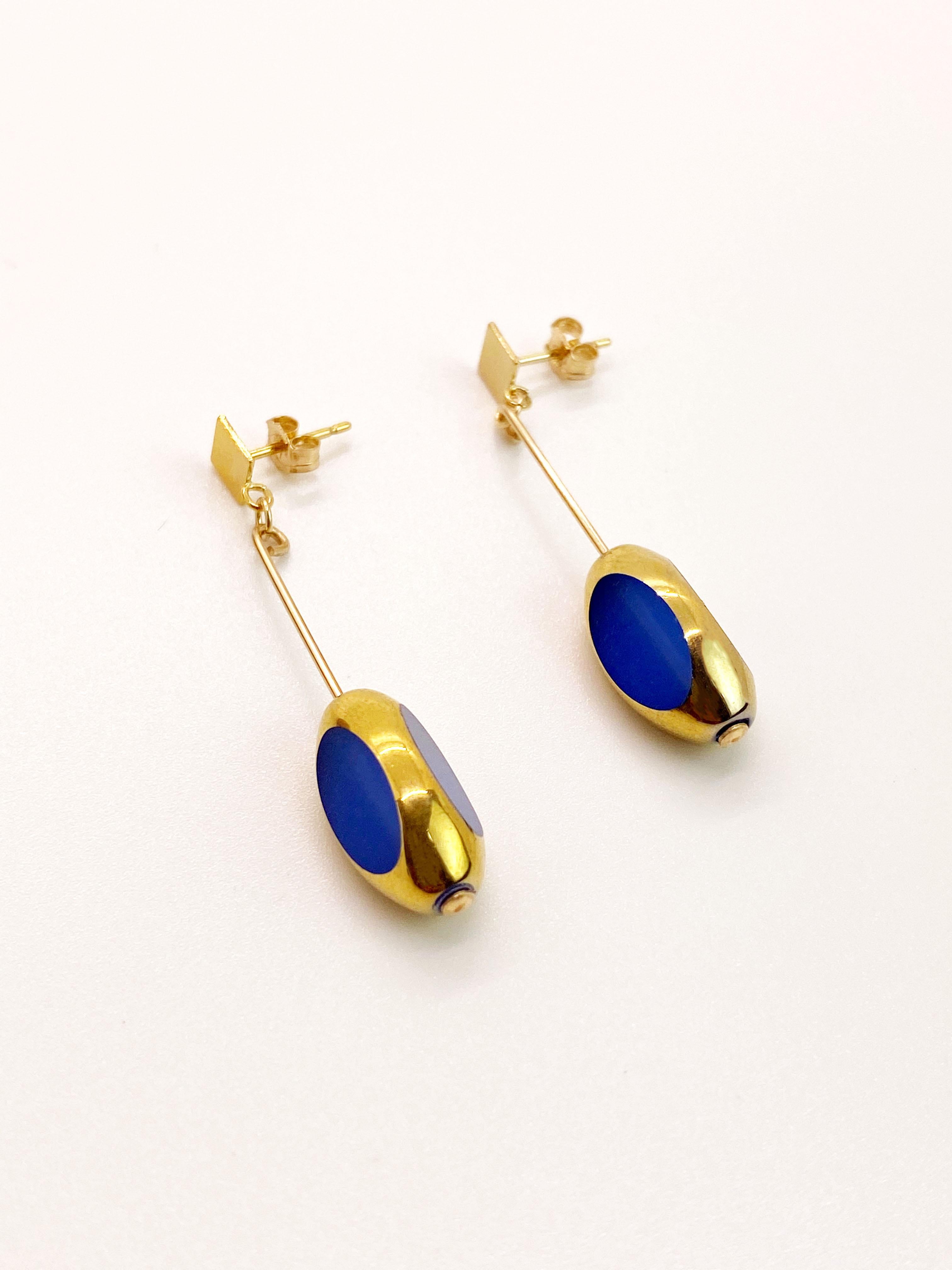 Matte Blue vintage German glass beads edged with 24K gold dangles on a 14K gold filled ear wire. 

The German vintage glass beads are considered rare and collectible, circa 1920s-1960s.