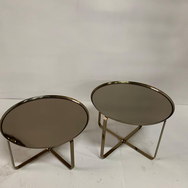 Contemporary, multipurpose low side tables in light brass matte finish with a mirror top.

Note: dimensions of taller table is 22.75 inches diameter and 16 inches tall, lower table is 22.75 inch diameter and 12 inches tall.