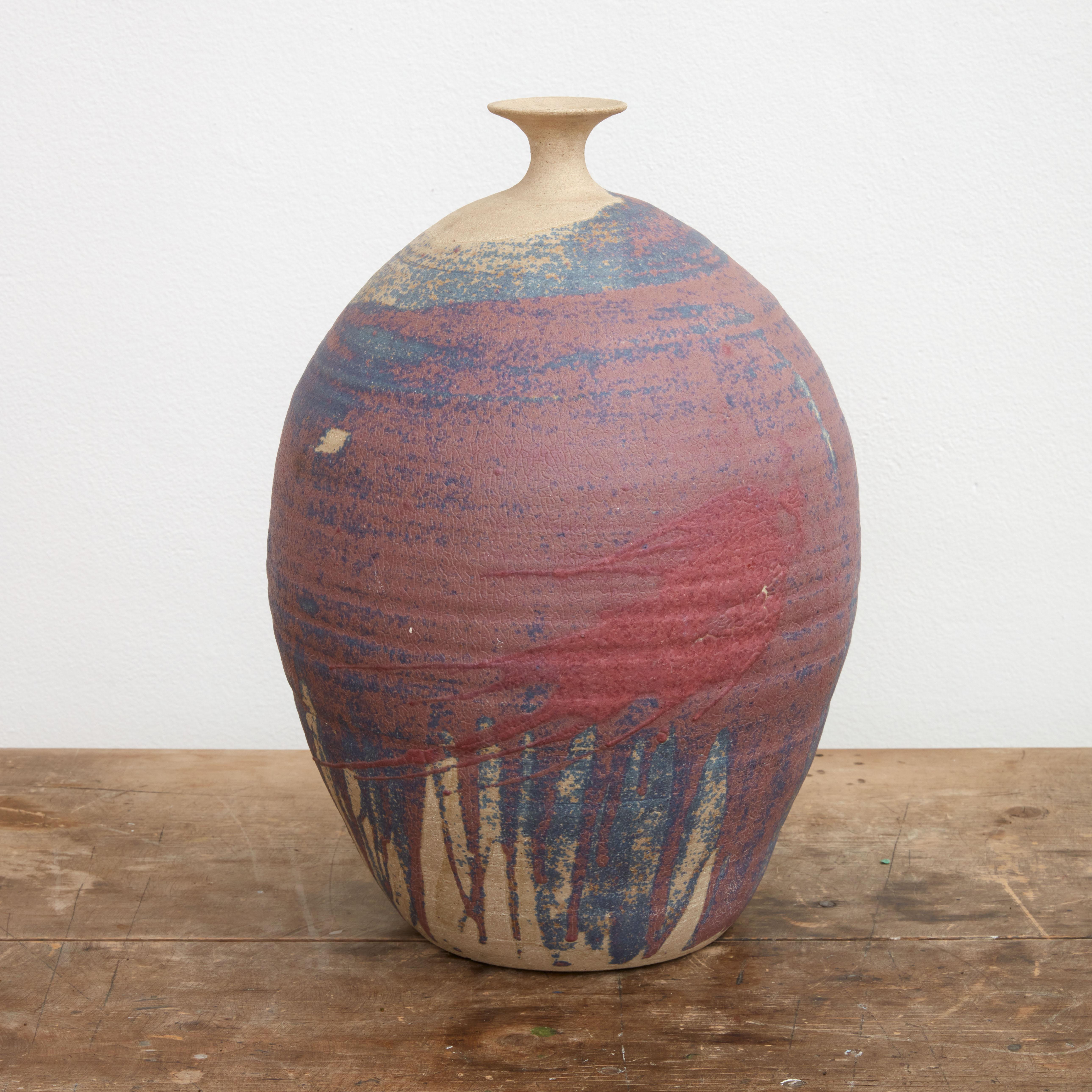 Signed narrow neck earthenware vase in drip style matte glaze.