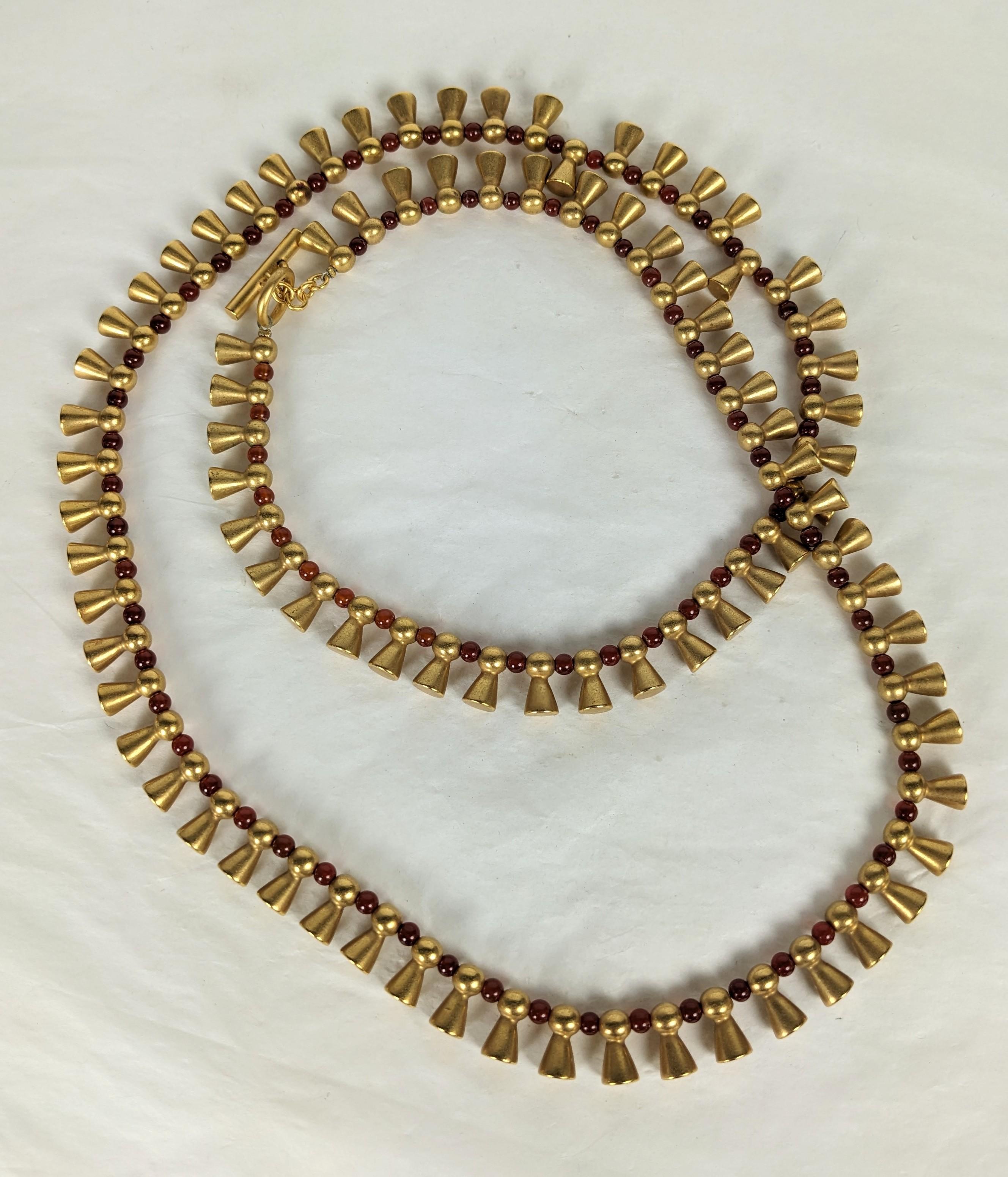 Eleganza della collana in oro opaco e corniola Pate de Verre di Vargas degli anni '90. I ciondoli in oro opaco dal sapore Pre-Columbian sono intervallati da perline in pate de verre che riproducono la corniola. Chiusura a T per una maggiore