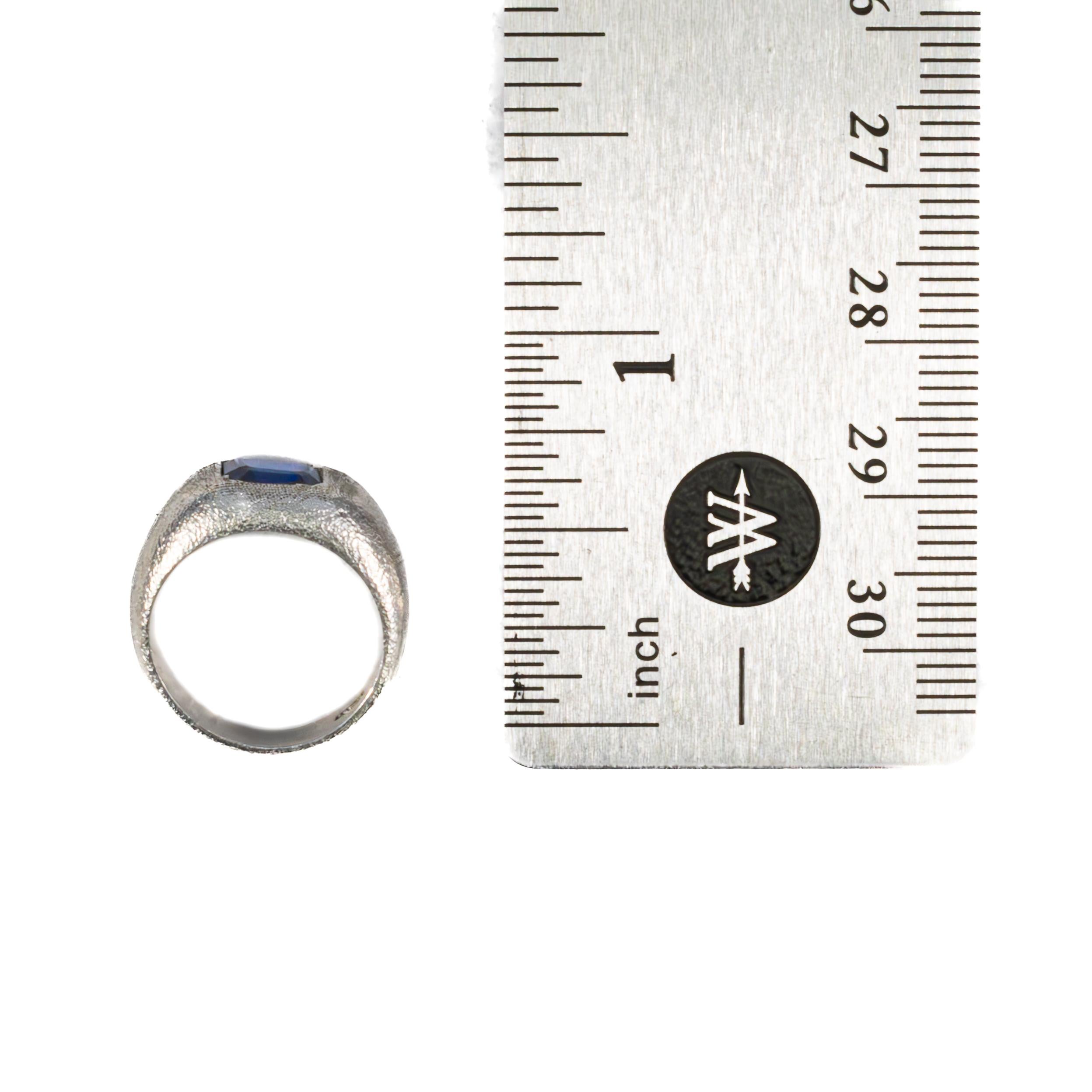 Matte Platinum Solitaire Sapphire Ring

A bold and modern statement, this platinum ring showcases a striking step-cut blue sapphire, bezel-set into a uniquely textured dome-shaped band. The sapphire, with its rich royal blue hue, stands out against