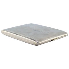 Matte silver cigarette case w/ borders on the edge, gold interior 
hinged lid