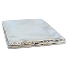 Matte silver cigarette case w/ borders on the edge, gold interior 
hinged lid