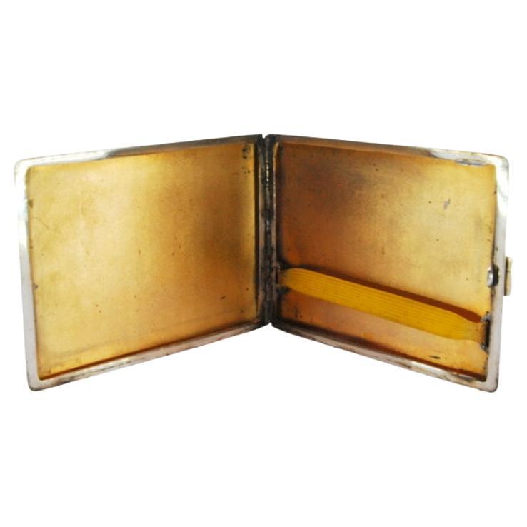Matte silver cigarette case w/ borders on the edge, gold interior 
hinged lid