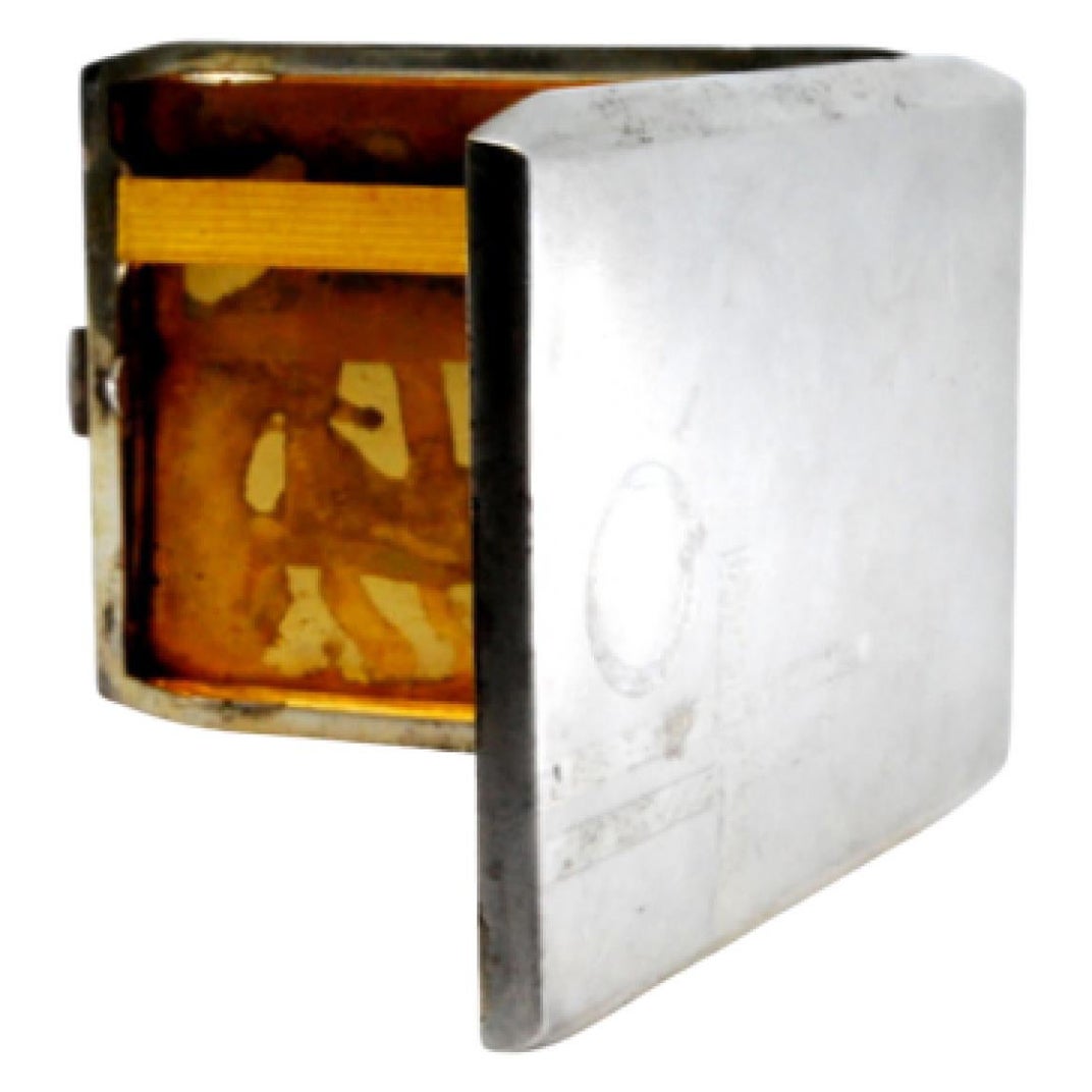 Matte silver cigarette case w/ gold interior
overlapping bands w/ hinged lid
