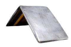 Portasigarette in argento opaco con strisce lungo il coperchio che circondano un cartoncino con monogramma