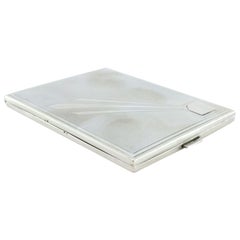 Matte silver cigarette case with a border around the edge and a monogram card