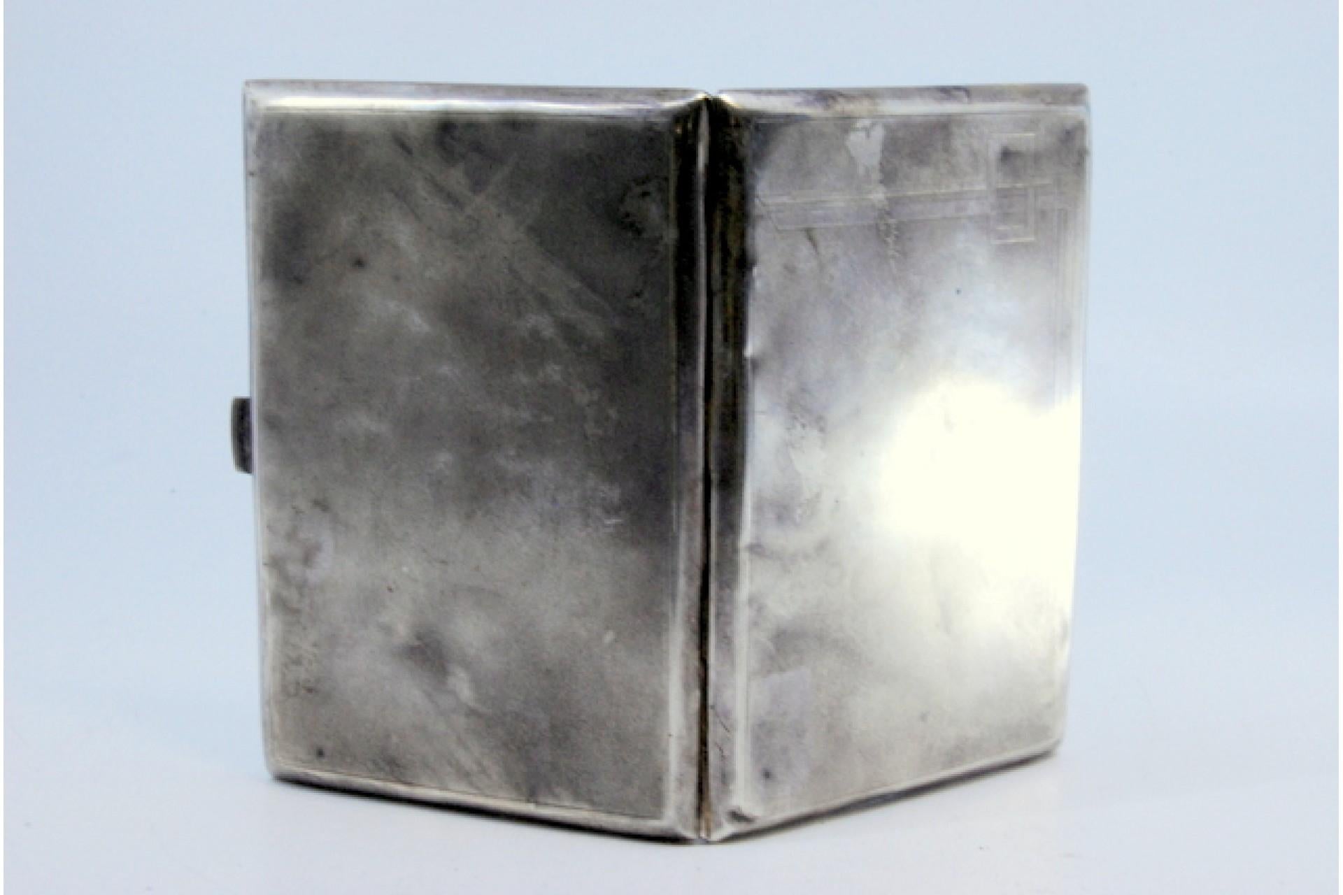Description: Matte silver cigarette case with geometric lines on the hinged lid. Metal: Silver. Origin: Portuguese. Brand: Eagle Head. Weight: 109.69 grams. Dimensions: 11.3x7.7cm. Content: 833/1000. Assay Mark: Yes, between 1938 and 1984.