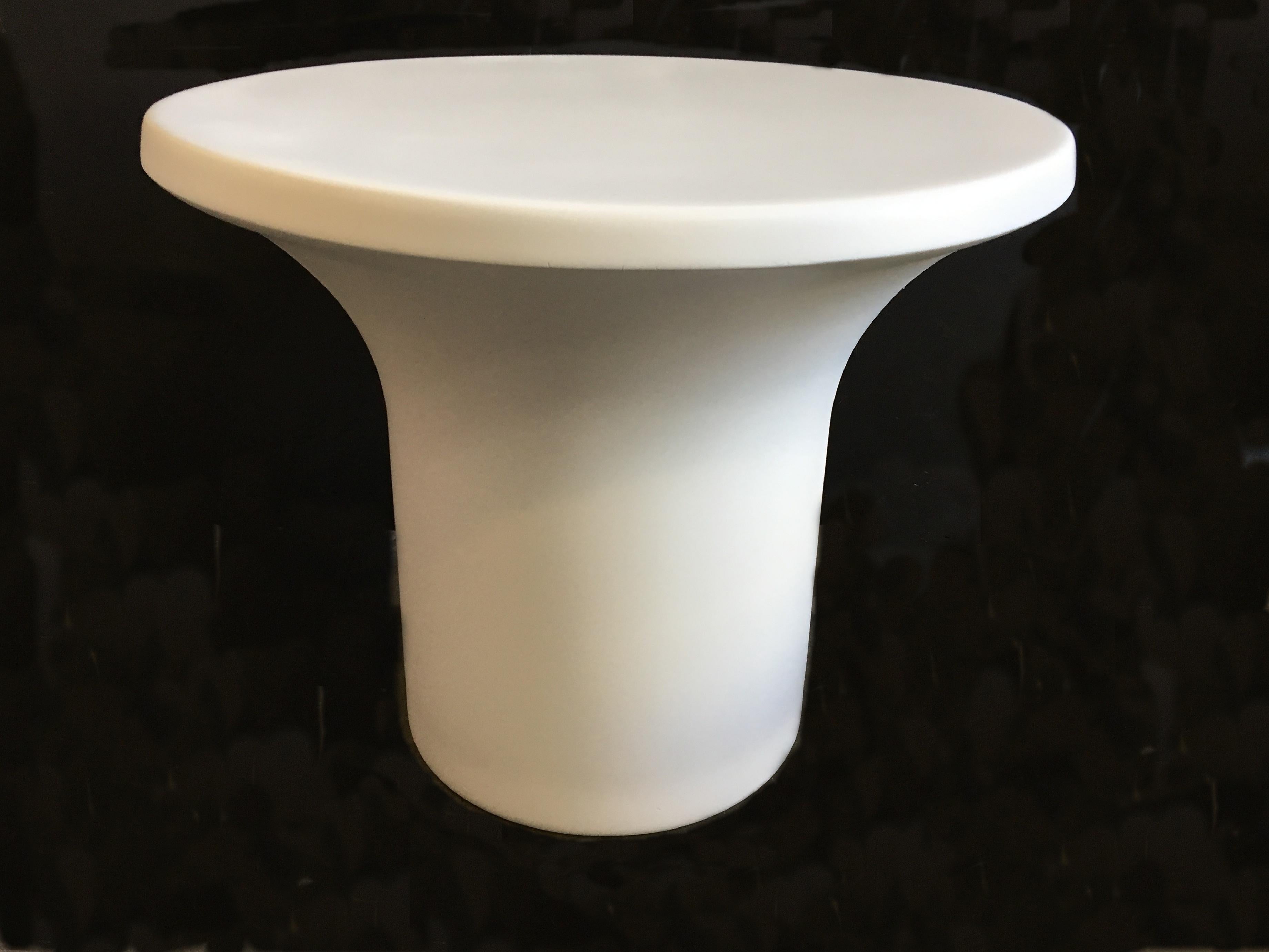 The base of this matte white fiberglass table is filled with concrete for more stability.