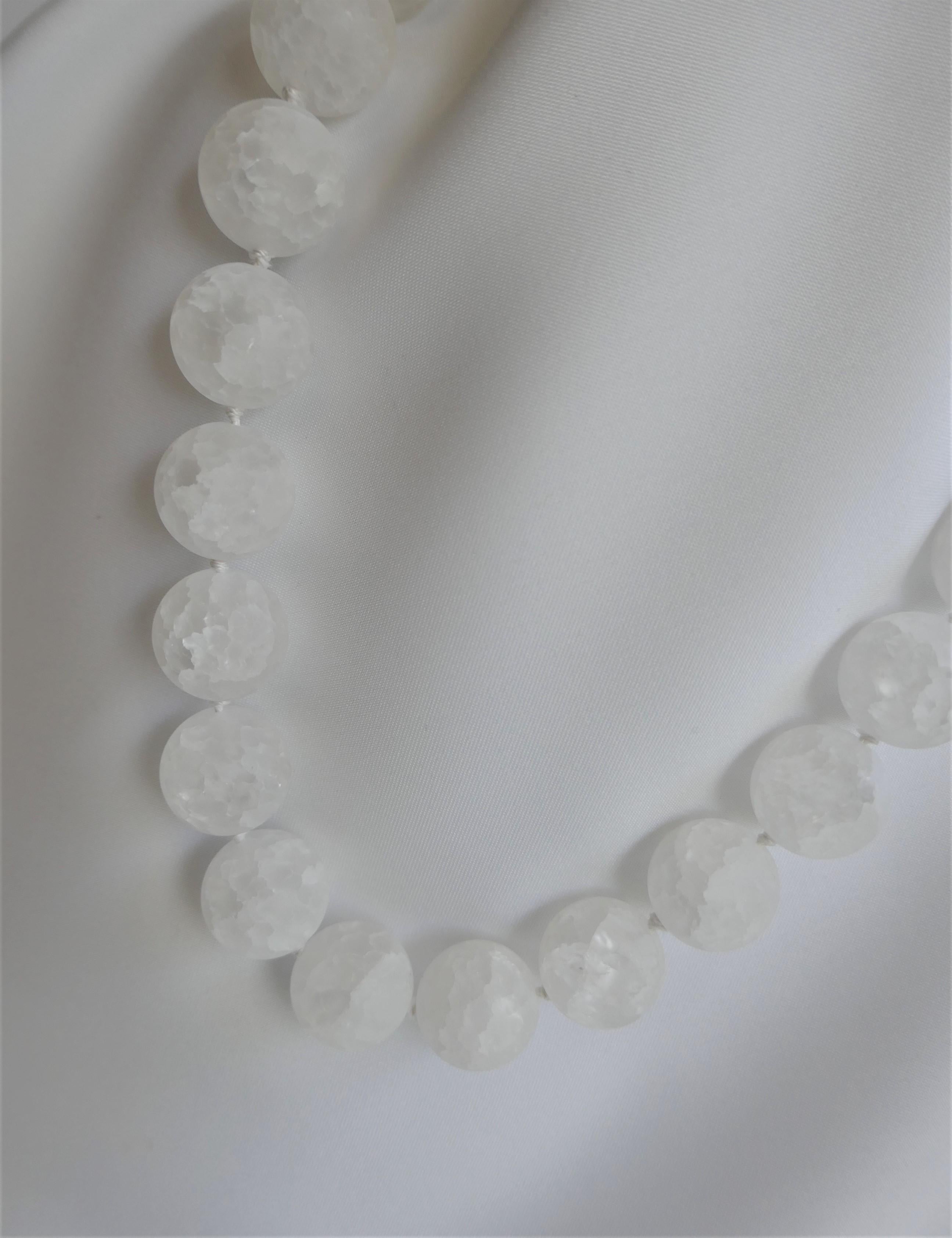 The photos do not capture the beauty of  this necklace. I love matted cracked rock crystal specially the large beads. Its a necklace that can be worn year round and looks great on. The rock crystal is 18mm, individually knotted on white silk thread