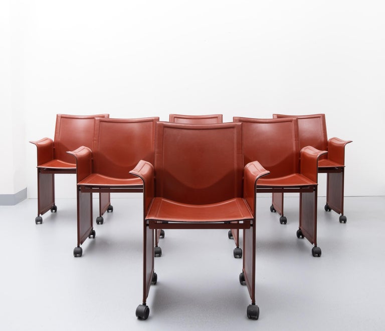 Six wonderful armchairs designed by Tito Agnoli for Matteo Grassi model Korium. Metal frame
all covered with top quality leather, in a superb orange red color. On wheels. Very comfortable
dining chairs. Good condition.
