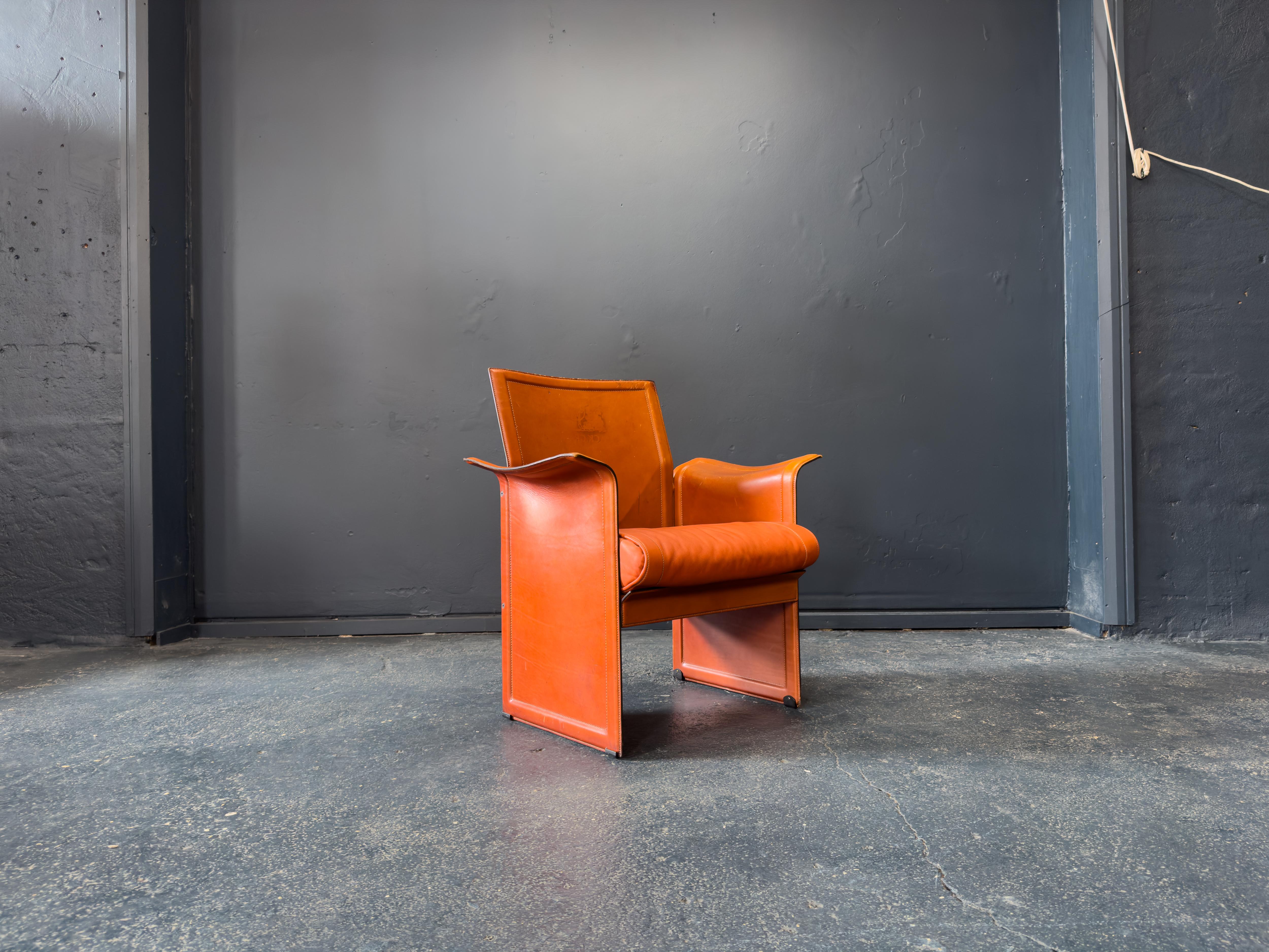 Designed by Matteo Grassi in the 1970s, the 'Korium' leather chair is a striking example of Italian modernism, celebrated for its bold sculptural form and luxurious materials. Crafted with sumptuous cognac leather, the chair's sleek, angular