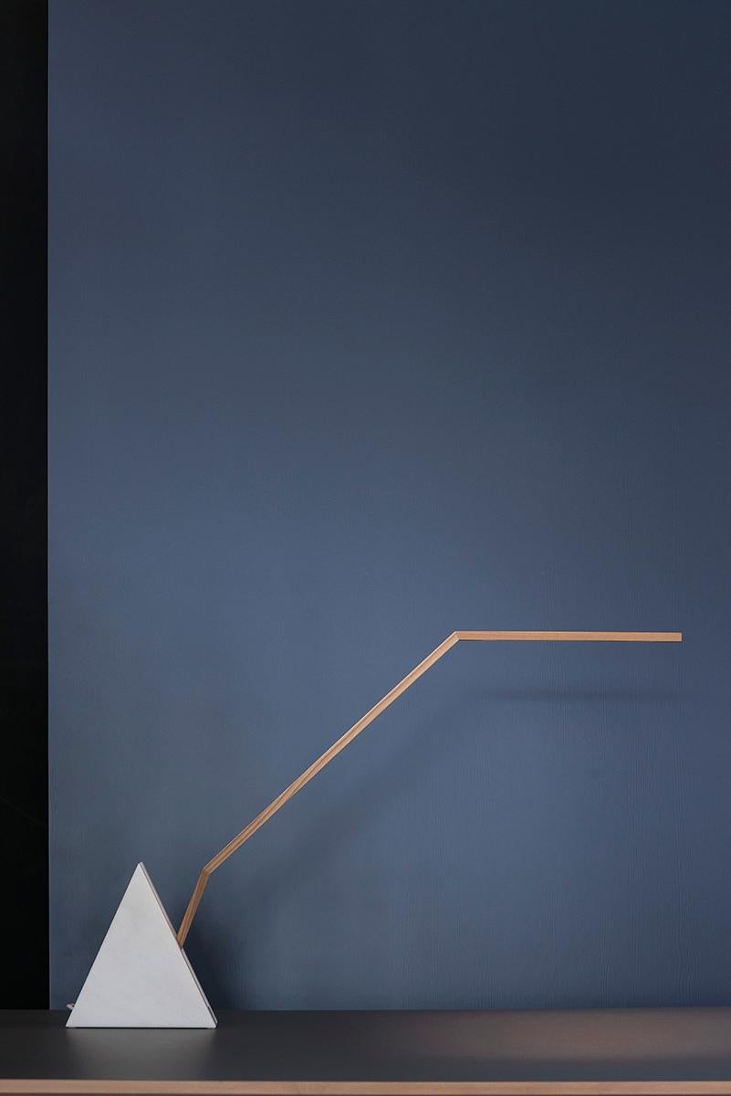 The LED table lamp Matterhorn is made up of two elements, a three-cornered base, made of white marble from Lasa in Val Venosta in South Tyrol and resembling a mountain top, and the movable stem of the lamp, made of wood.
If the stem is in a