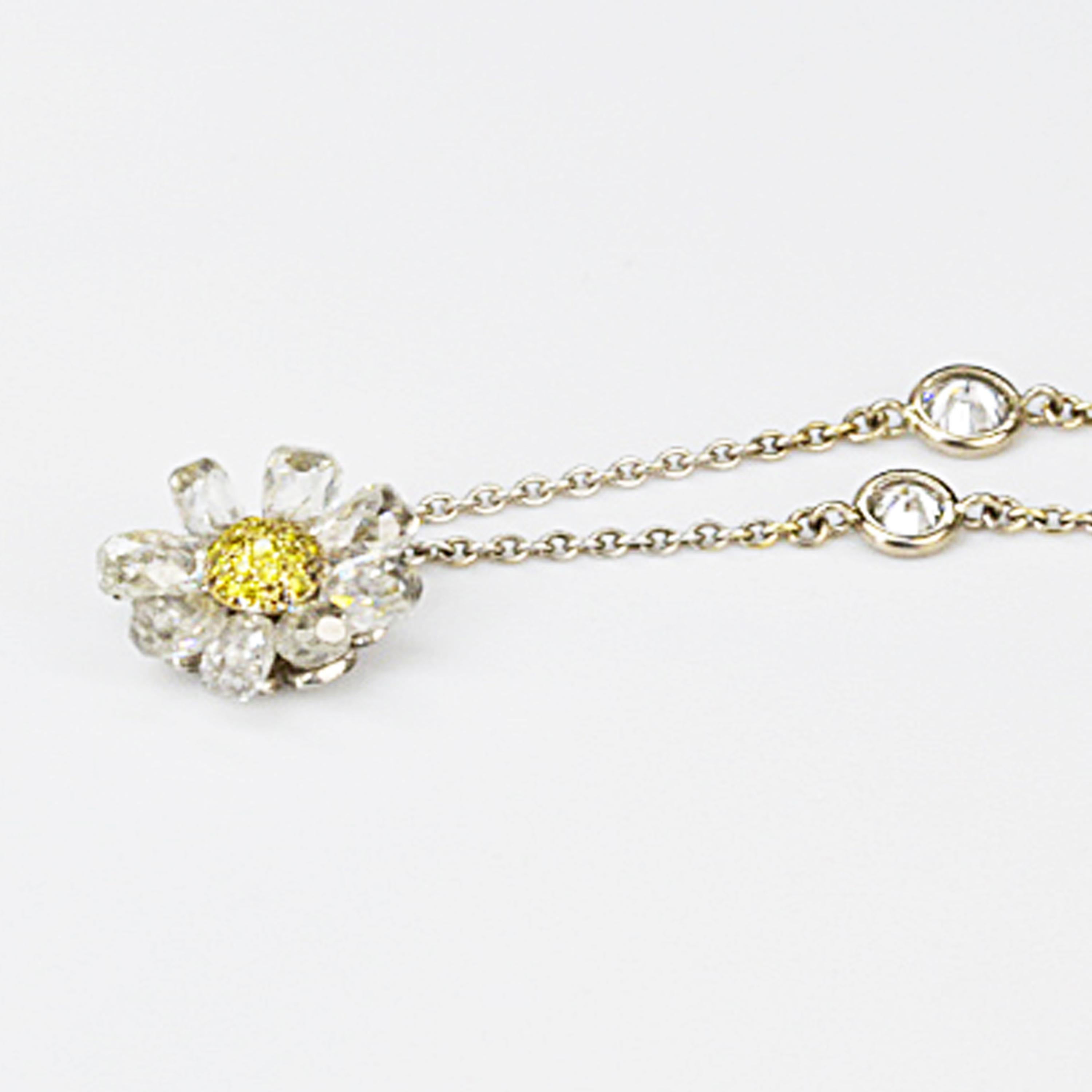 Matthew Cambery Platinum and 18K Yellow Gold Daisy pendant comprising 8 briolette white diamonds with a central pave yellow diamond central section. The chain has spectacle set diamonds.
