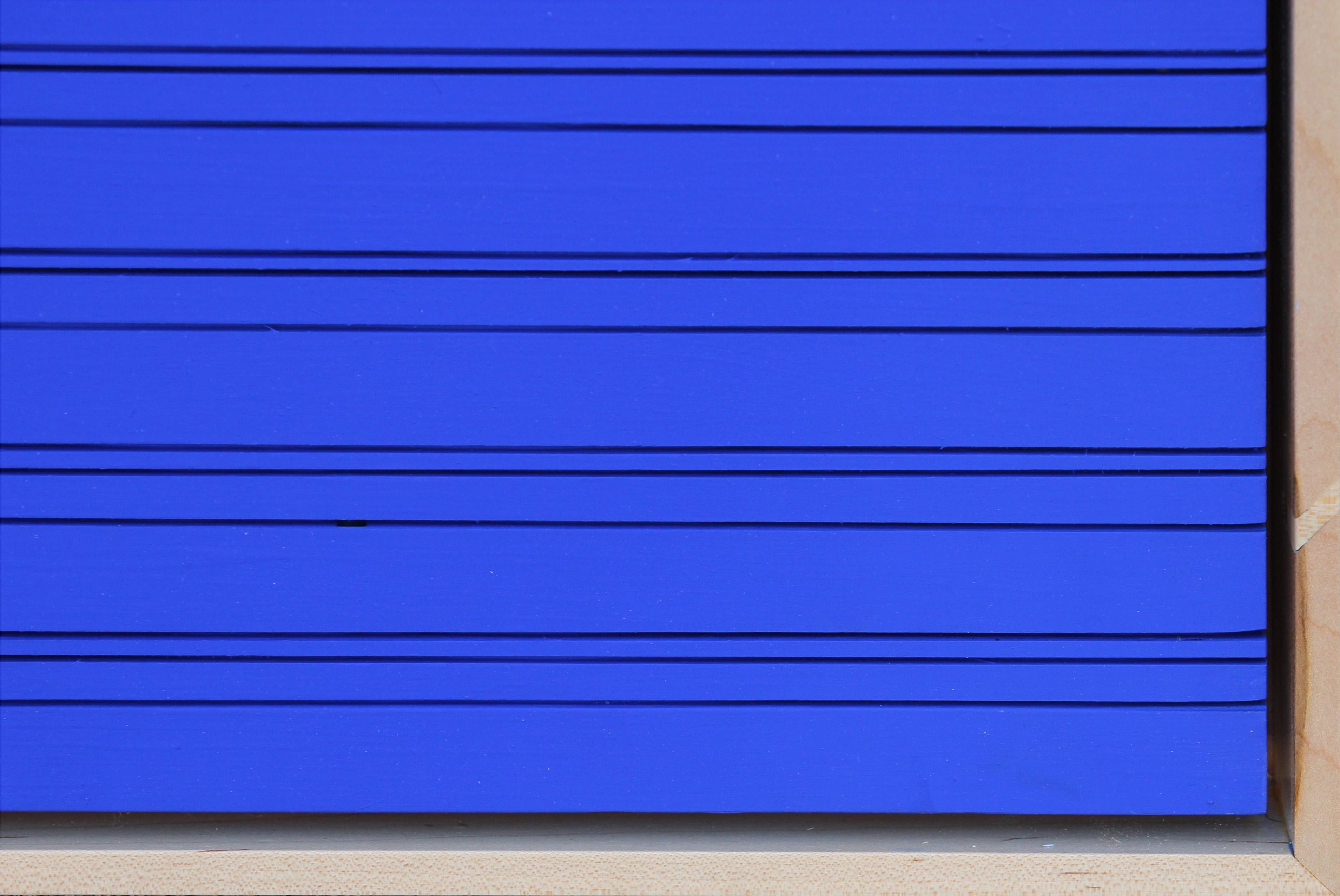 Abstract wall sculpture painting featuring intersecting linear grooves painted with Yves Klein blue paint. The uniqueness of 