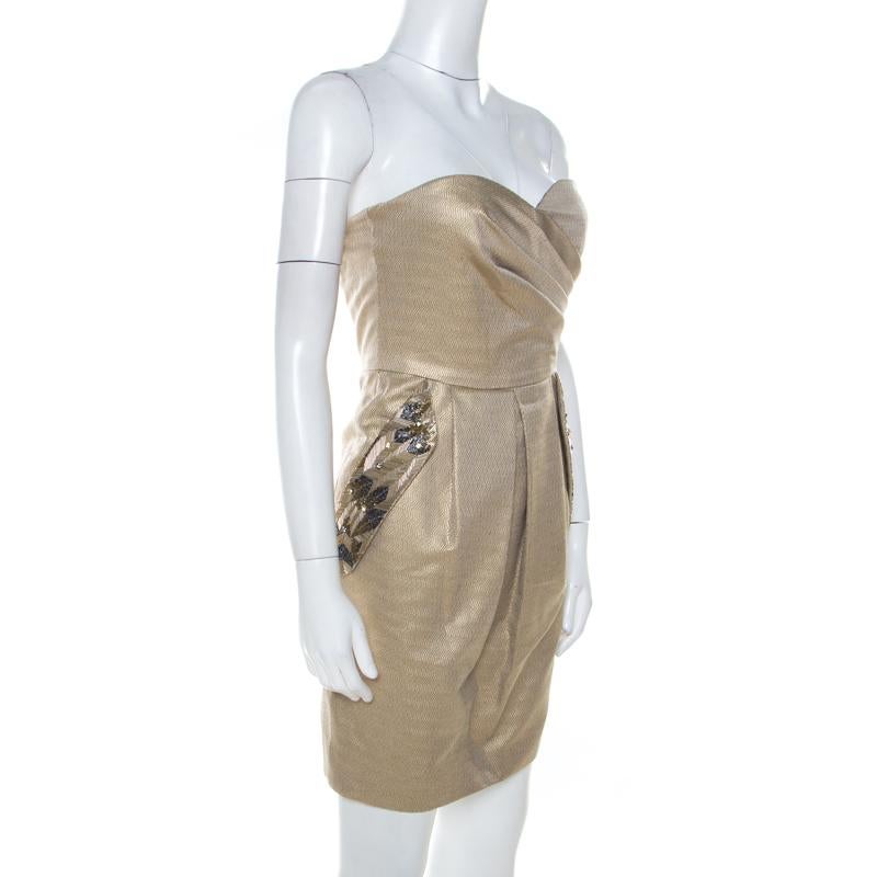 An elegant staple, this dress from Matthew Williamson comes in a lovely gold shade. This creation is made of a cotton blend and flaunts embellished side pockets. The dress has a fitted waist and features asymmetric pleats at the bodice and a zip
