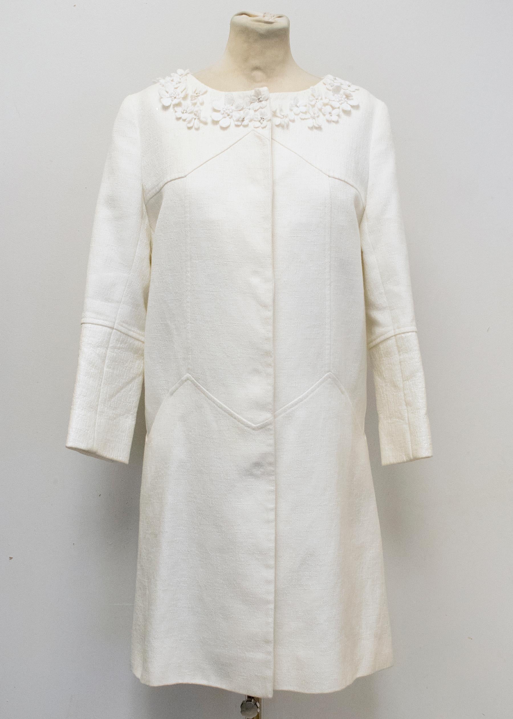 New
RRP 1125.00GBP

Simple lines and modern fabric. This coat is a summer wardrobe essential. Embroidered with clusters of daisies at the neckline, it also becomes an ornate piece for the evening.
The neckline is trimmed with daisy lace embroidery,