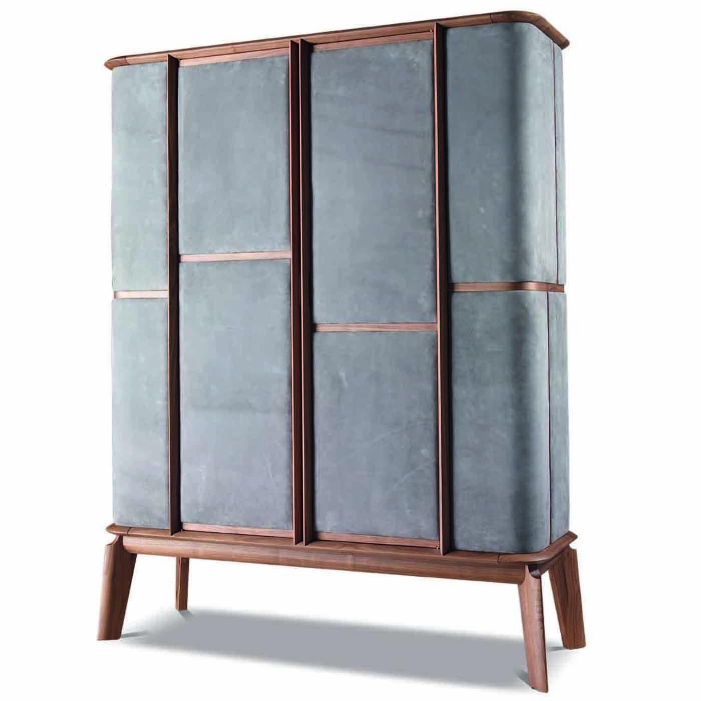 Solid walnut wood makes the structure of this cabinet that is a functional piece of design. The slanted legs evoke the charm of midcentury Furniture, while precious panels of grey-colored nubuck leather upholstery the sides and front to add elegance