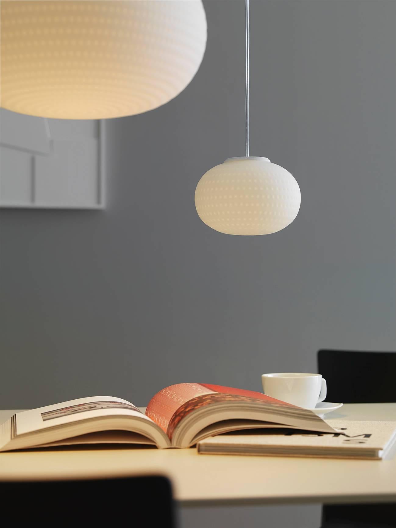 Designed by Matti Klenell in 2015 and manufactured by Fontana Arte, the Bianca suspension lamp is a family of lamps with diffuser in blown glass, comprising pendant, floor, wall/ceiling and table versions, the latter with or without base. Its
