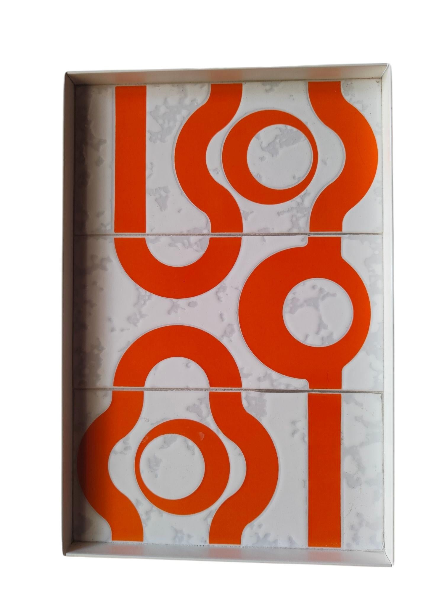 una composición muy rara de tres azulejos de cerámica fabricados por Cedit Italia en los años 70, diseñados por jean Pierre Garrault y henri Delord, sobre fondo blanco con motivos geométricos en naranja.
Cada baldosa mide 21,6 x 10,8 cm, por lo que