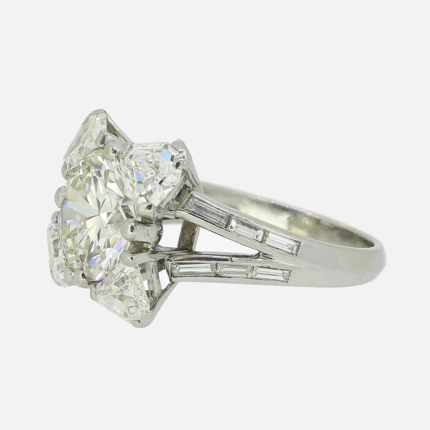 Here we have a sensational statement ring by Mauboussin. This platinum piece was crafted shortly after the reside of the Art Deco movement and showcases a remarkable 4.24 carat round brilliant-cut diamond at the centre of the face, exuding radiance