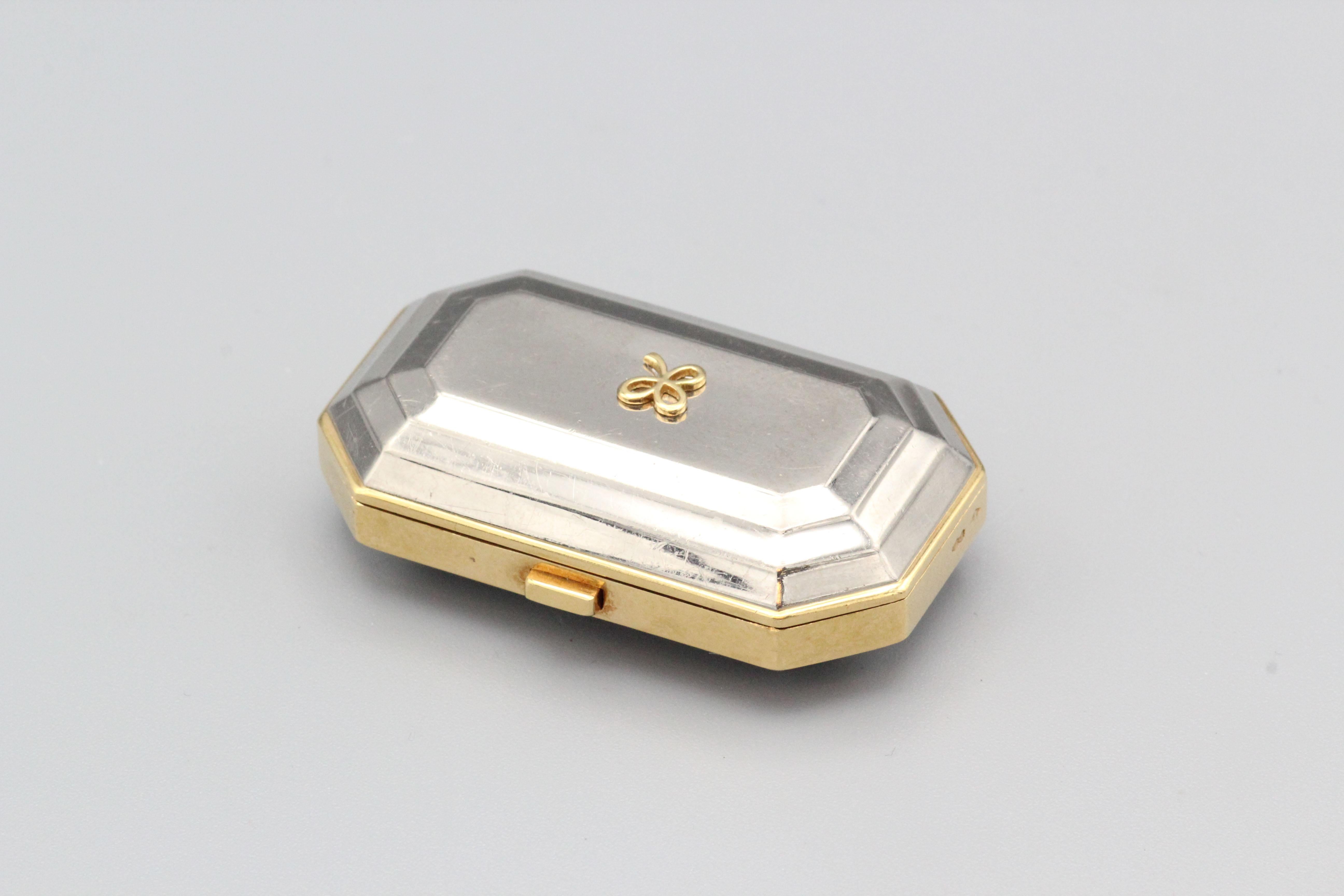 Fine 18K yellow and white gold pill box by Mauboussin, circa 1990s.

This modern Mauboussin pill box is a stunning and functional piece of jewelry. The pill box is made from high-quality 18k white and yellow gold, giving it a luxurious and