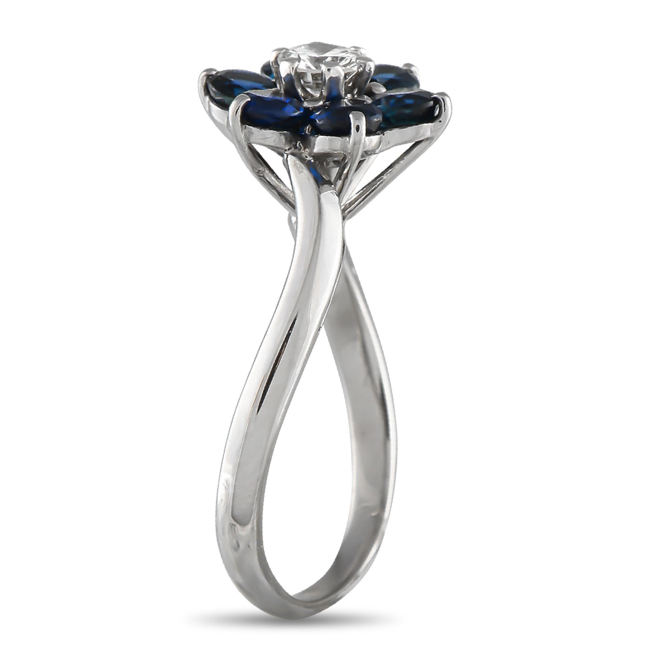 Questo anello di Mauboussin è sorprendente nella sua semplicità. Una fascia curva realizzata in oro bianco 18 carati aggiunge un impatto visivo al design understated.design. Al centro, un motivo floreale realizzato con gemme di diamante e zaffiro