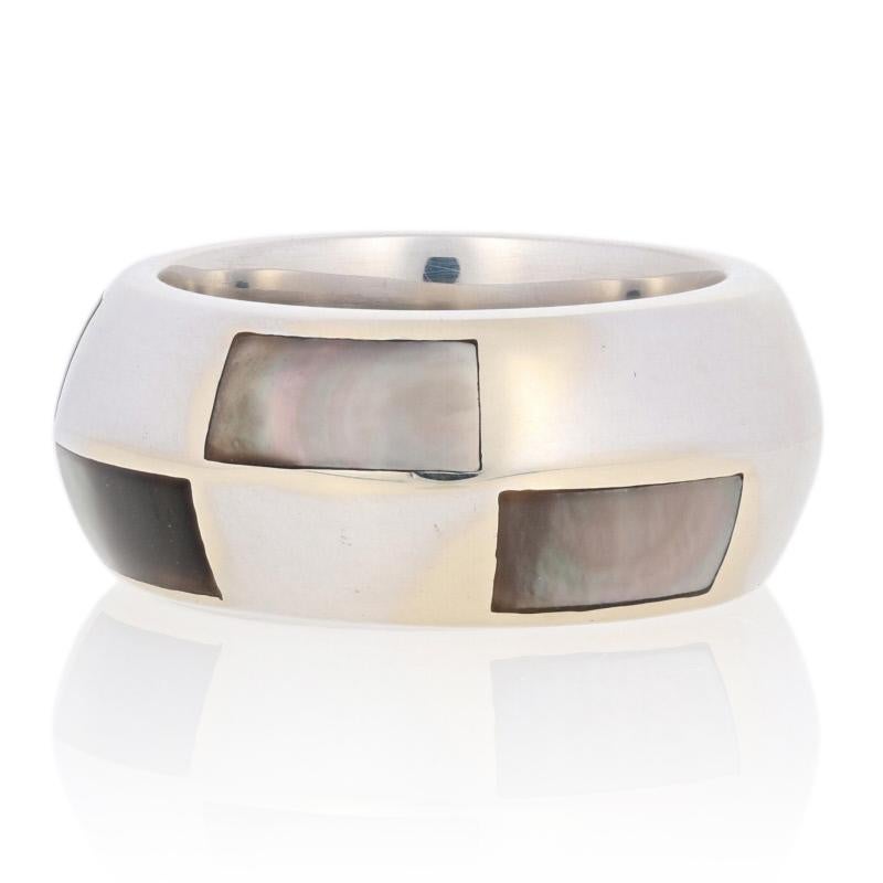 Add a touch of French sophistication to your wardrobe with this tres chic designer ring! Artistically crafted by Mauboussin, this wide knife-edge band showcases black mother of pearl set in 18k white gold to create a beautiful play of light you will
