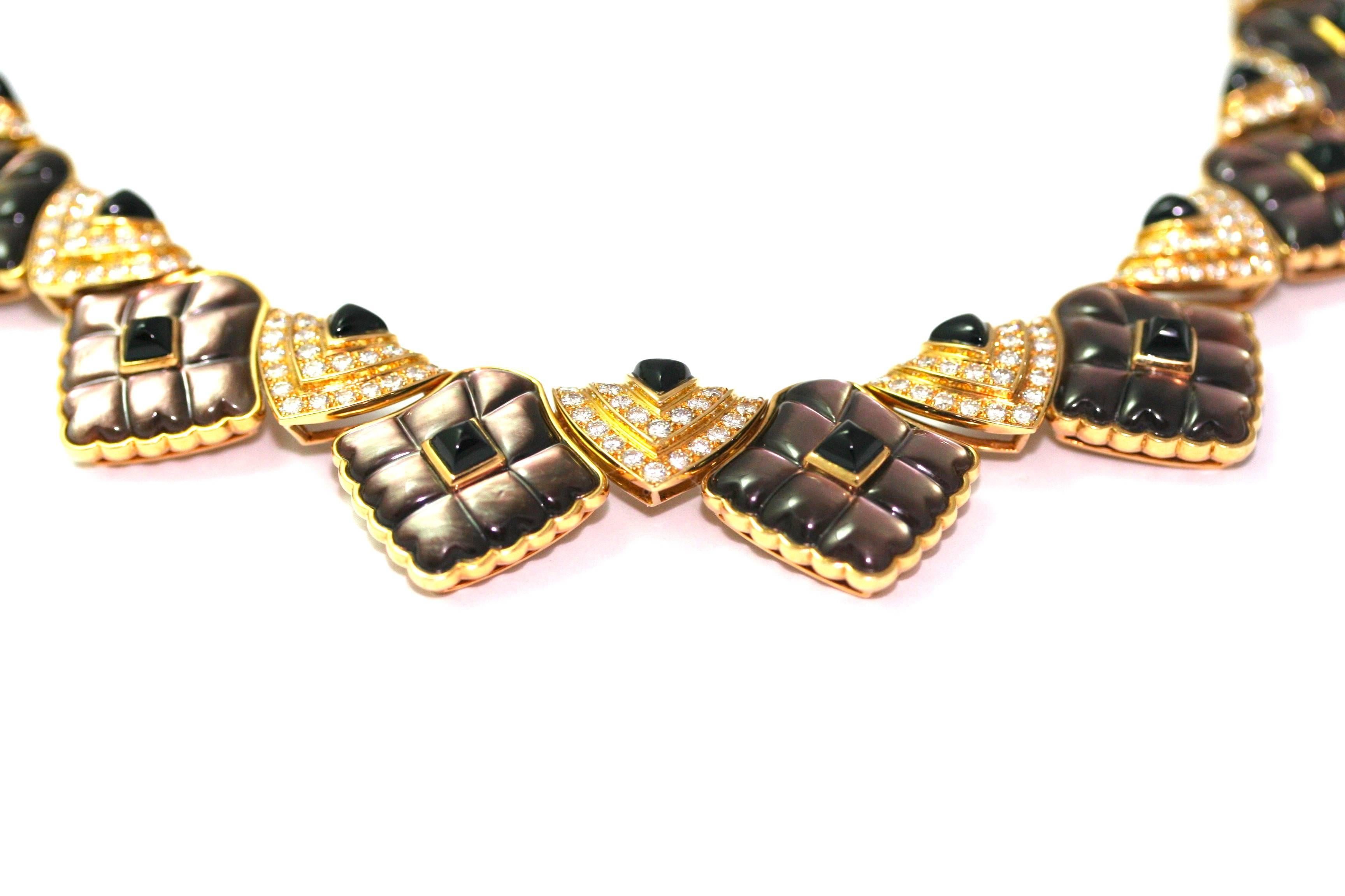 Rare collier Mauboussin réalisé dans les années 70-80. 
Ce collier est composé de différentes formes géométriques.
14 motifs triangulaires sertis de diamants et d'onyx en pain de sucre, les 5 motifs centraux sont plus grands, avec deux rangées de
