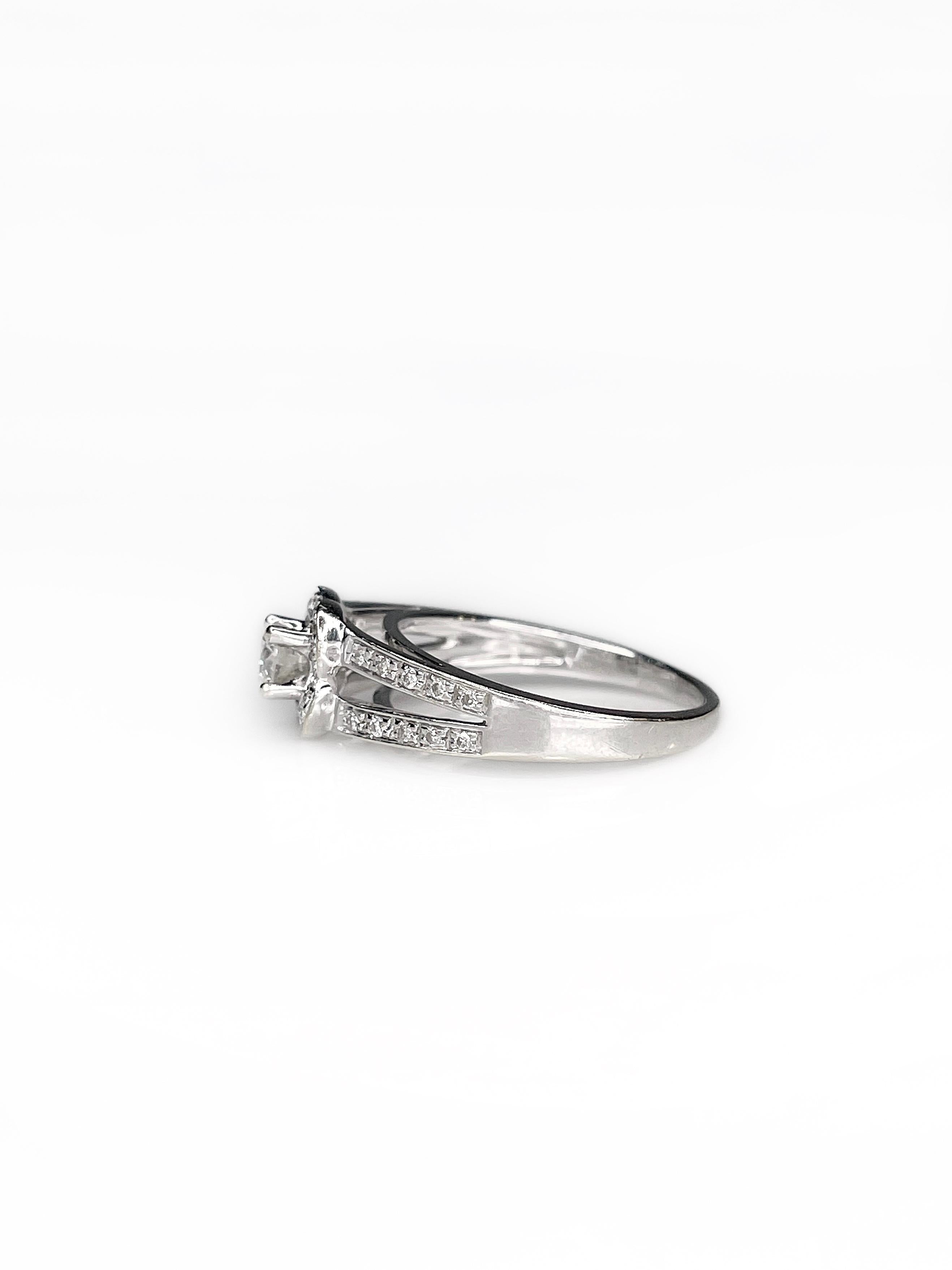 Il s'agit d'une belle bague solitaire en or blanc 18 carats.  La pièce est ornée d'un diamant brillant de 0,20 ct (couleur - W, pureté - SI1) au centre. Il est accompagné de 32 diamants plus petits, pesant au total 0,15ct (couleur - W/Tinted W,