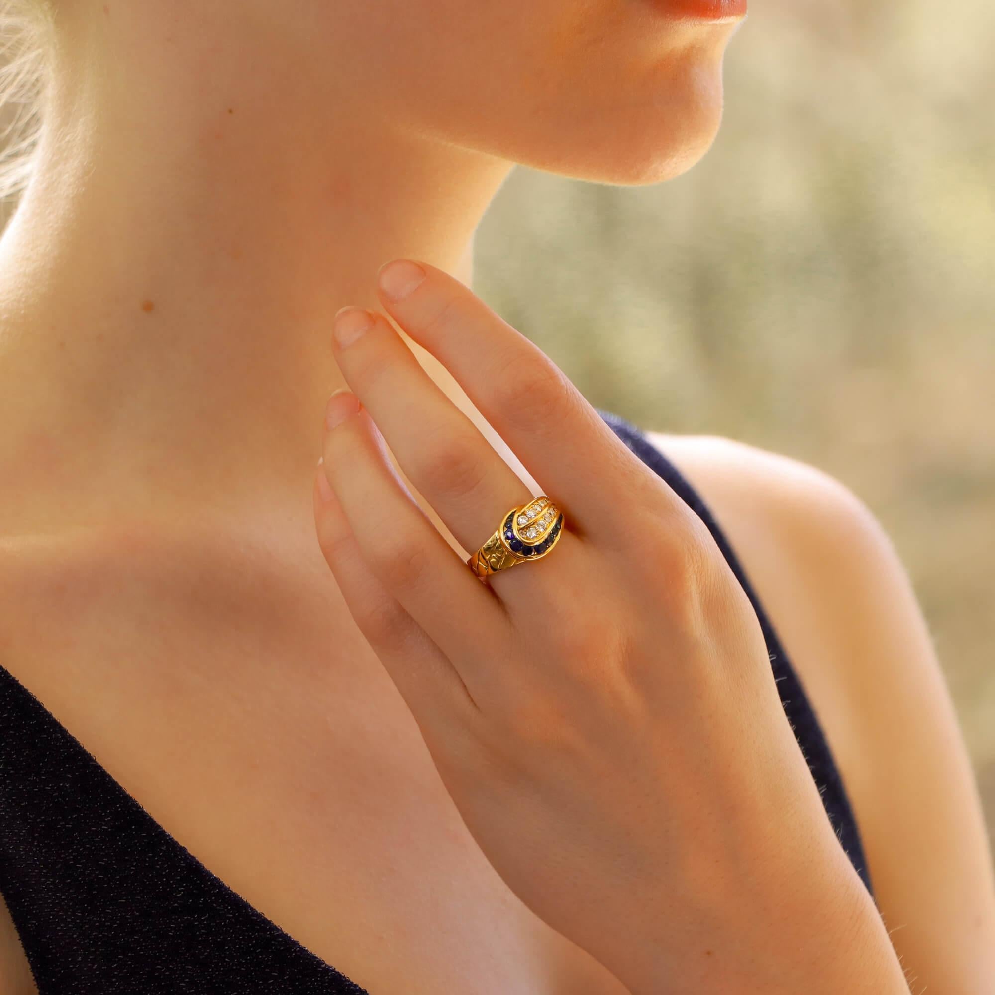 
A wonderful vintage diamond and sapphire ring signed, Mauboussin Paris and numbered. 
Set in 18kt yellow gold this unique ring features a swirling leaf motif with two rows of eighteen pave set round brilliant cut diamonds bordered by a sweeping row