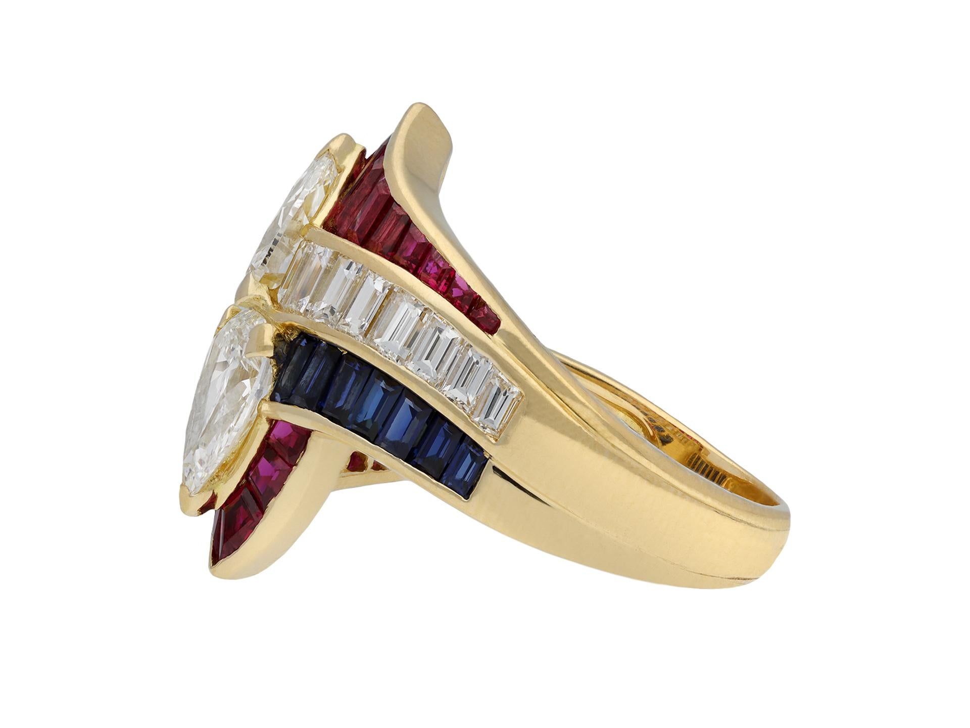 Mauboussin diamond, ruby and sapphire crossover ring. Set with two drop shape brilliant cut diamonds in open back claw settings with a combined approximate weight of 2.10 carats, flanked by sixteen rectangular baguette cut diamonds in open back