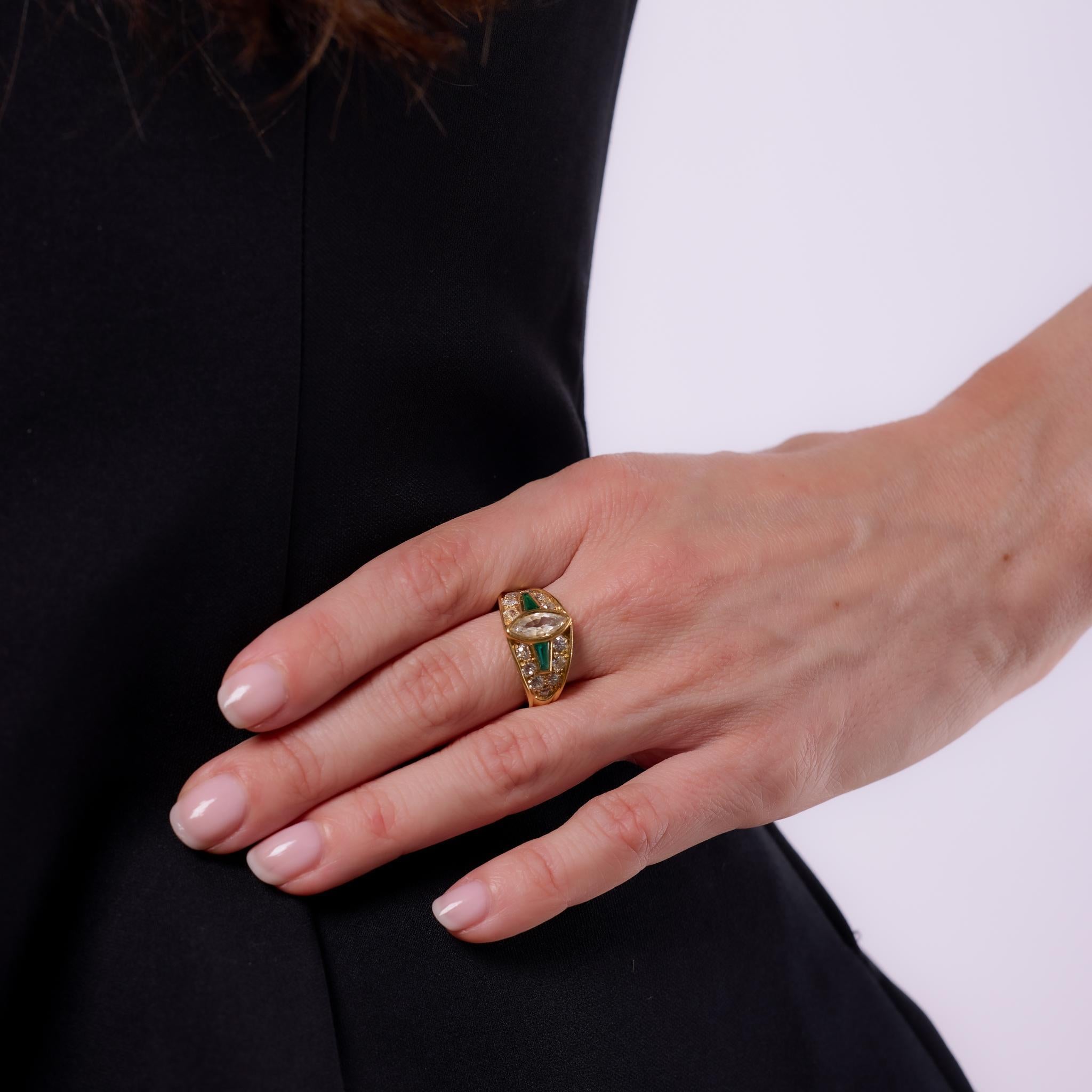 Crafted in the 1970s, this vintage Mauboussin bezel-set ring showcases a marquise cut diamond of approximately .45 carats, graded K color and VS2 clarity. Framed by 14 old European cut diamonds totaling approximately .70 carats, and accented by two