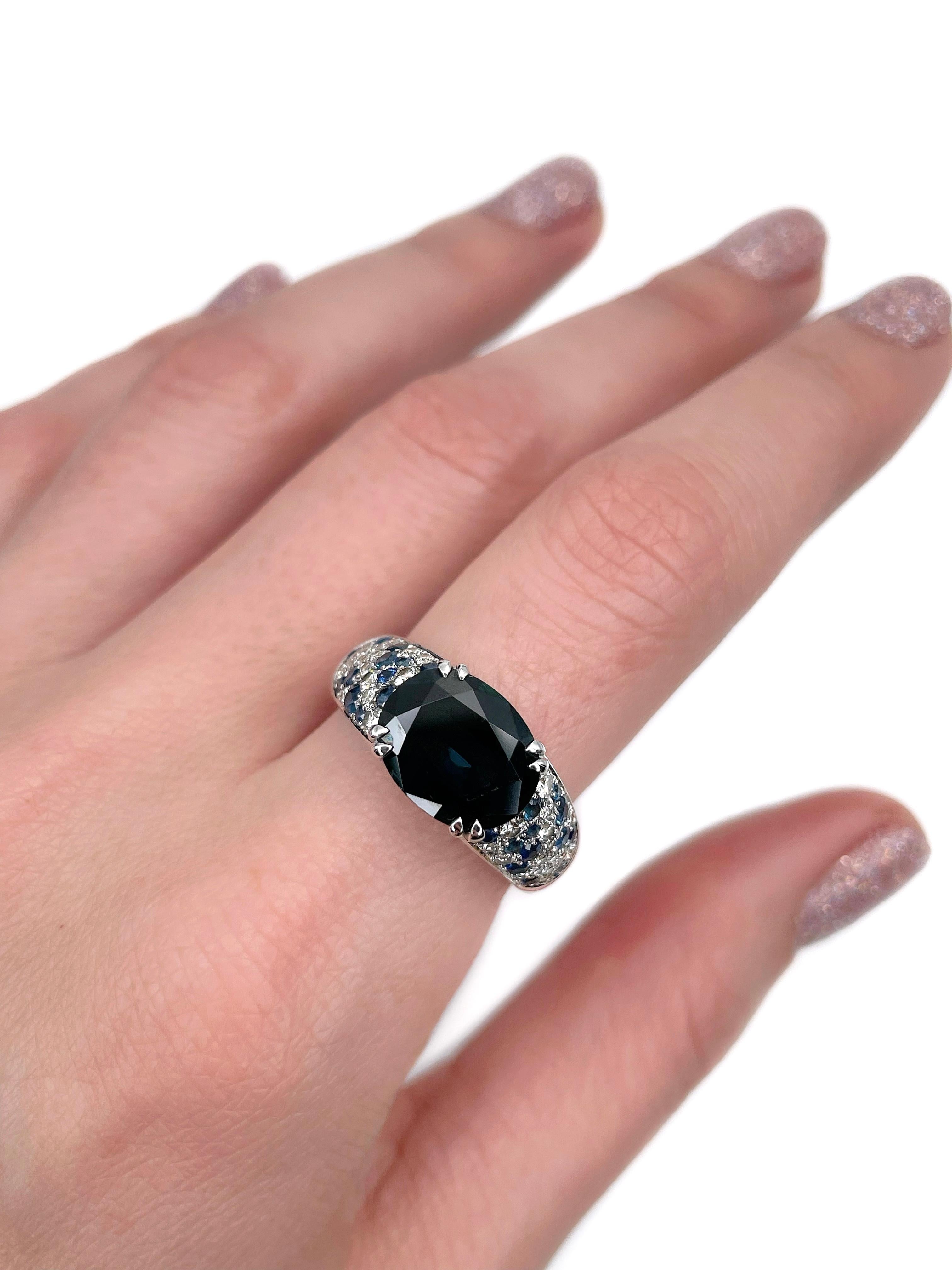 This is an amazing ring designed by Mauboussin for the “Nuit d’Amour” collection. Circa 2000. 

It is crafted in 18K white gold. The piece features:
- blue sapphires (central ~4.20ct, side TW ~0.62ct)
- round brilliant cut diamonds (TW
