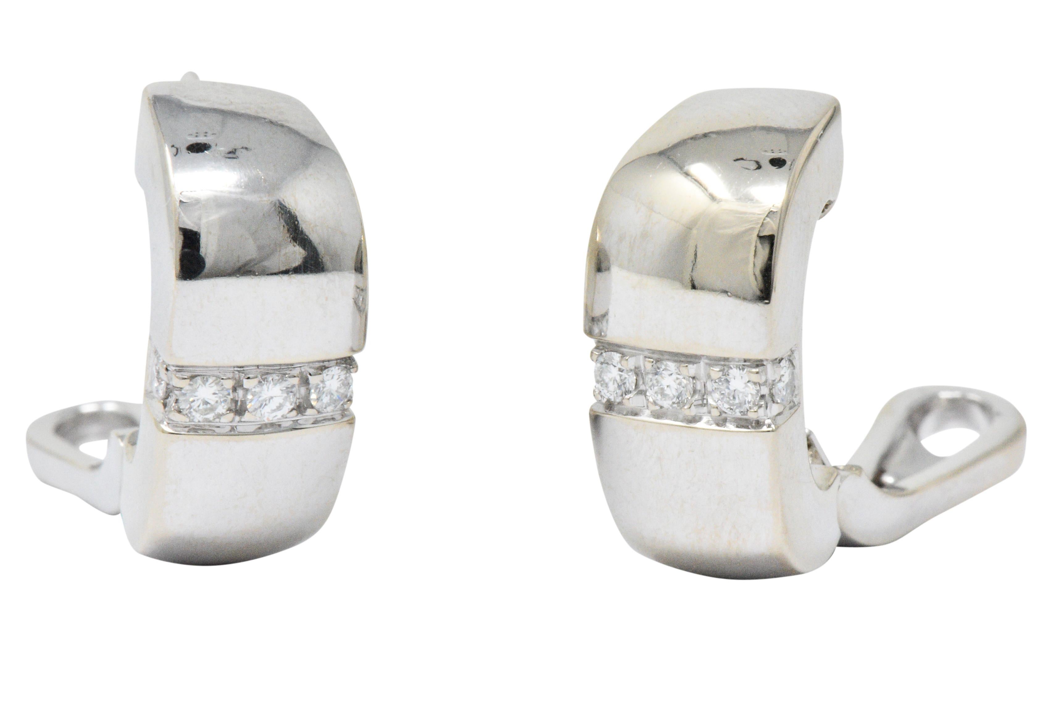 Earrings designed as brightly polished cushion shaped huggie hoops 

Each centers a row of round brilliant cut diamonds, bead set East to West, weighing in total approximately 0.40 carat; E/F color with VS clarity

Completed by hinged omega backs