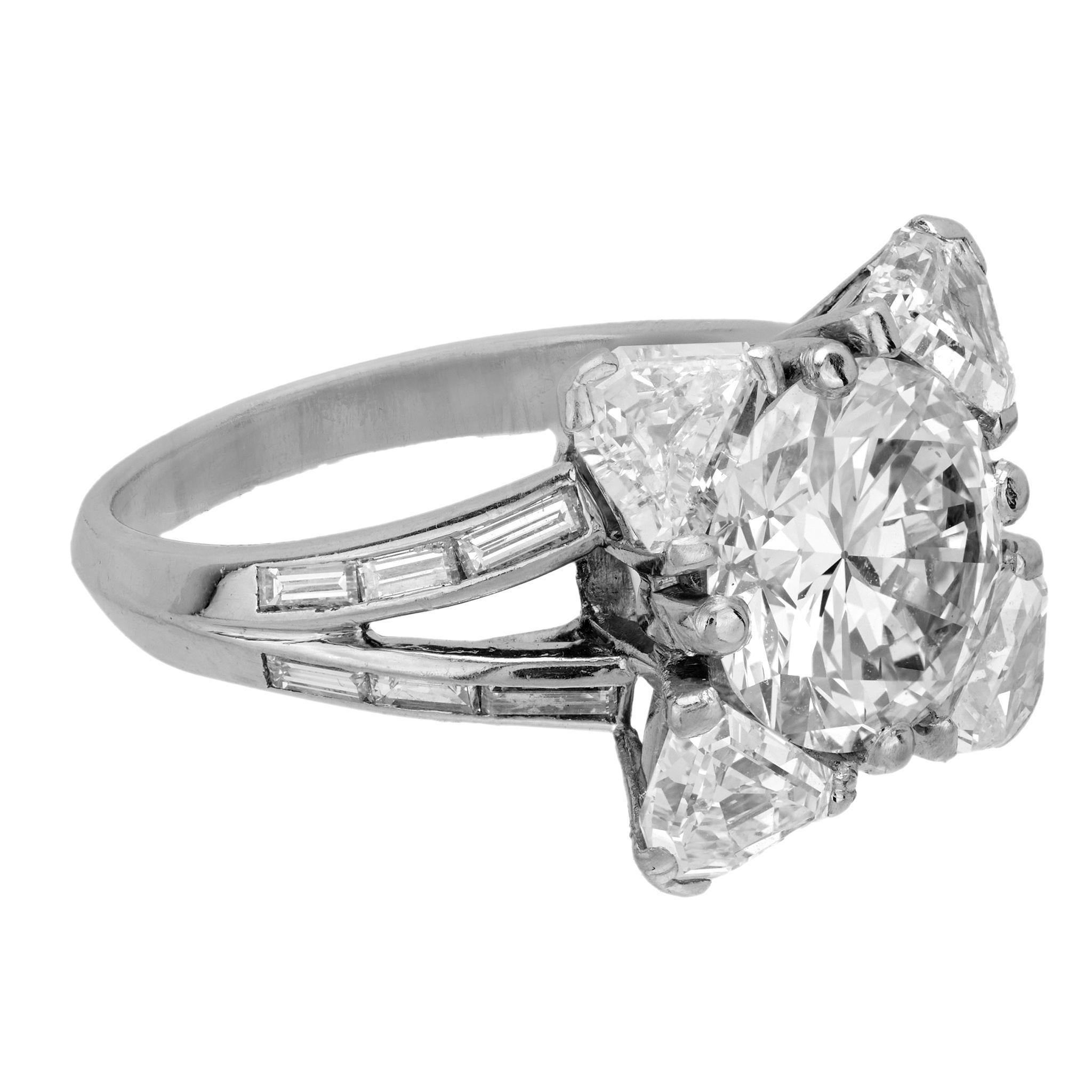 Este excepcional anillo Mauboussin Paris de platino centra un deslumbrante diamante de talla europea antigua de 4,24 quilates, enmarcado por raros diamantes de talla escudo y baguette antiguos. Una declaración de los años 50 magistralmente