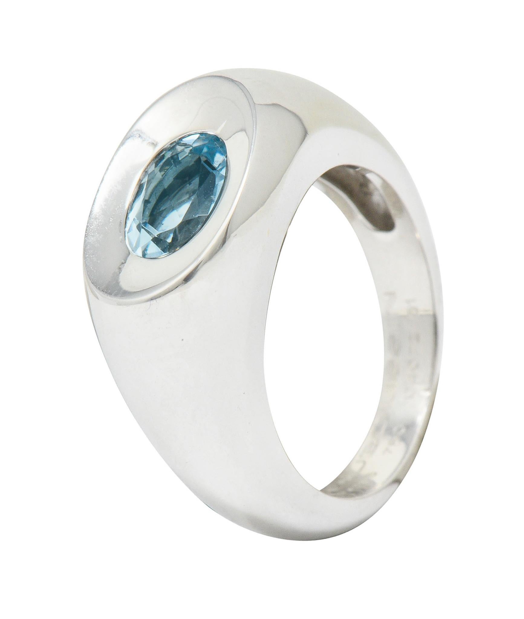 Polished white gold bombé stye band ring with a concave top

Featuring a flush set oval cut blue topaz measuring approximately 7.3 x 5.3 mm; light blue in color

Numbered, fully signed Mauboussin Paris, and with maker's mark

Stamped 750 and with