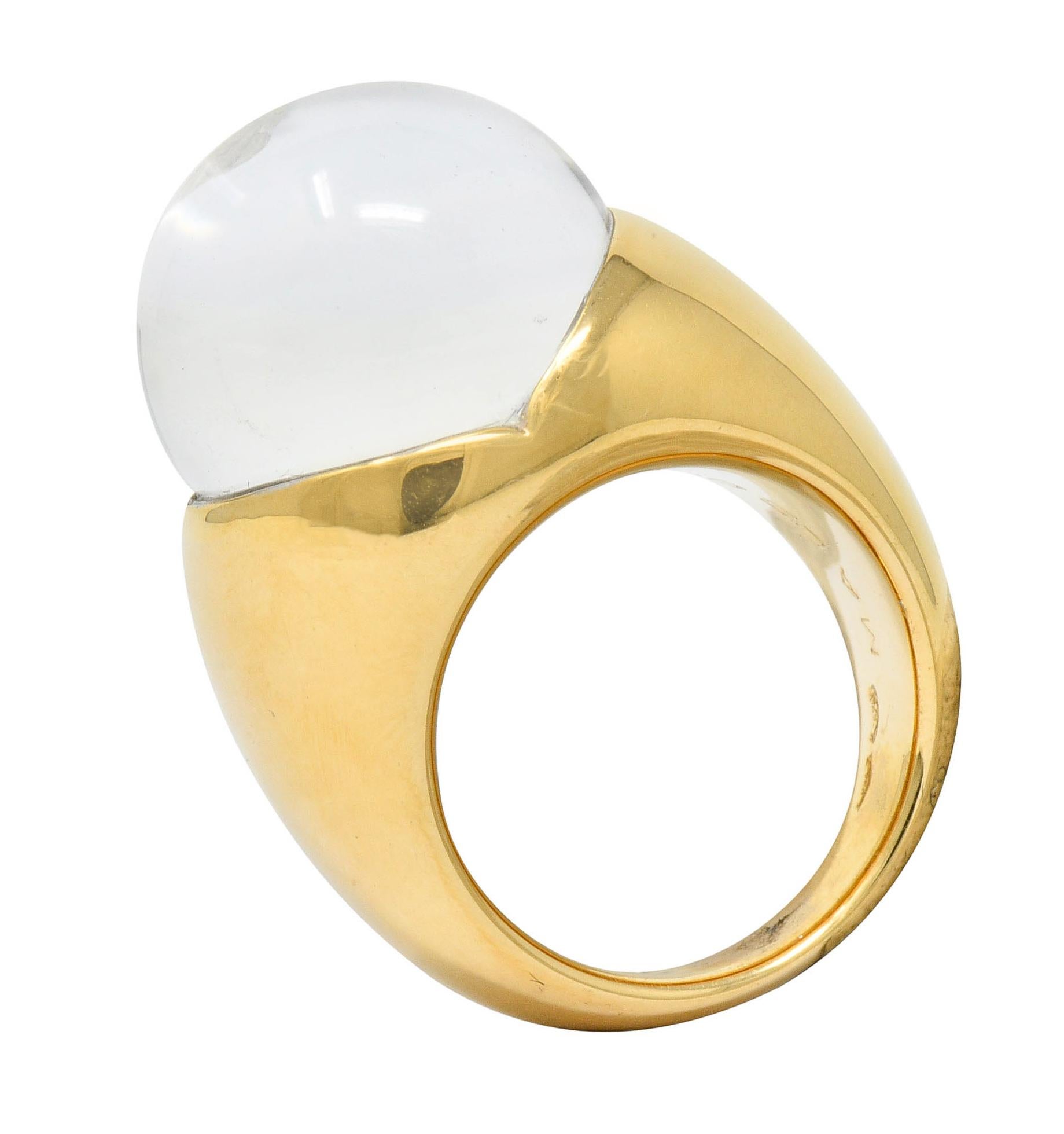 Featuring a considerable 15.6 mm round rock crystal orb, completely transparent	
	
Centering a flush set round brilliant cut diamond; magnified through well-polished orb		

Nestled securely in a stylized mounting with a bright finish	
	
With French