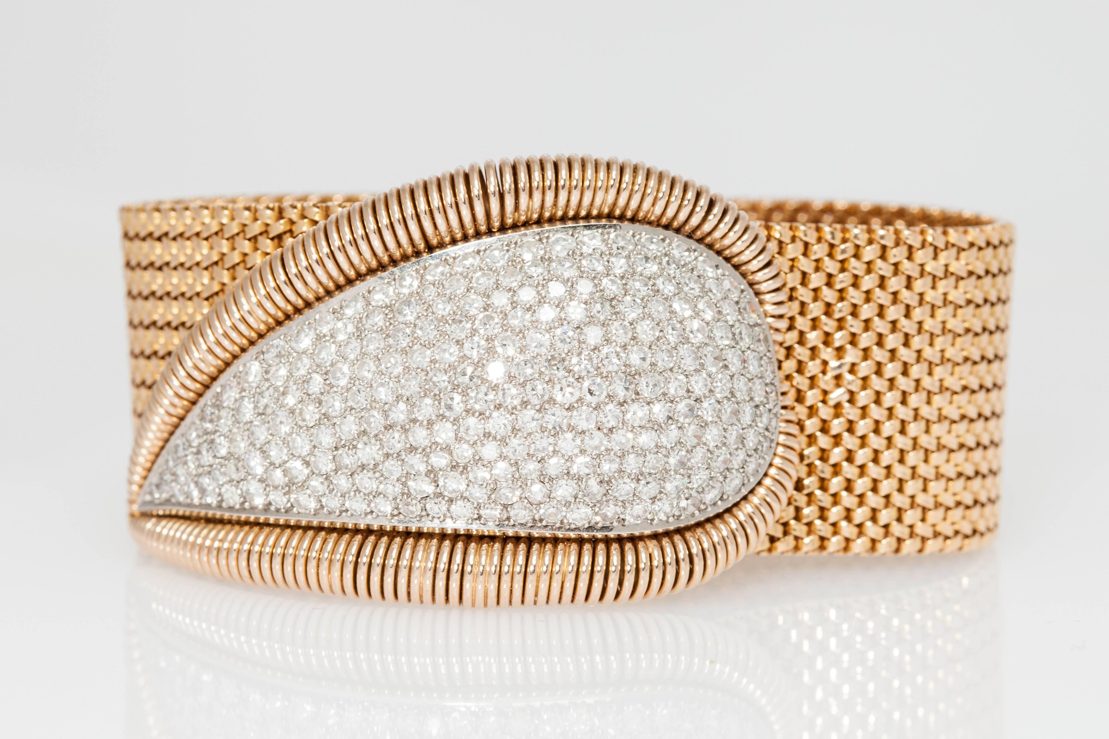 A sublime 18kt yellow knitted yellow gold bracelet, enhanced with a leaf shaped motif with a frame of circular structured gold containing approximately 10cts of fine round cut diamonds. Made in France (hallmarked) by Mauboussin, circa 1950.