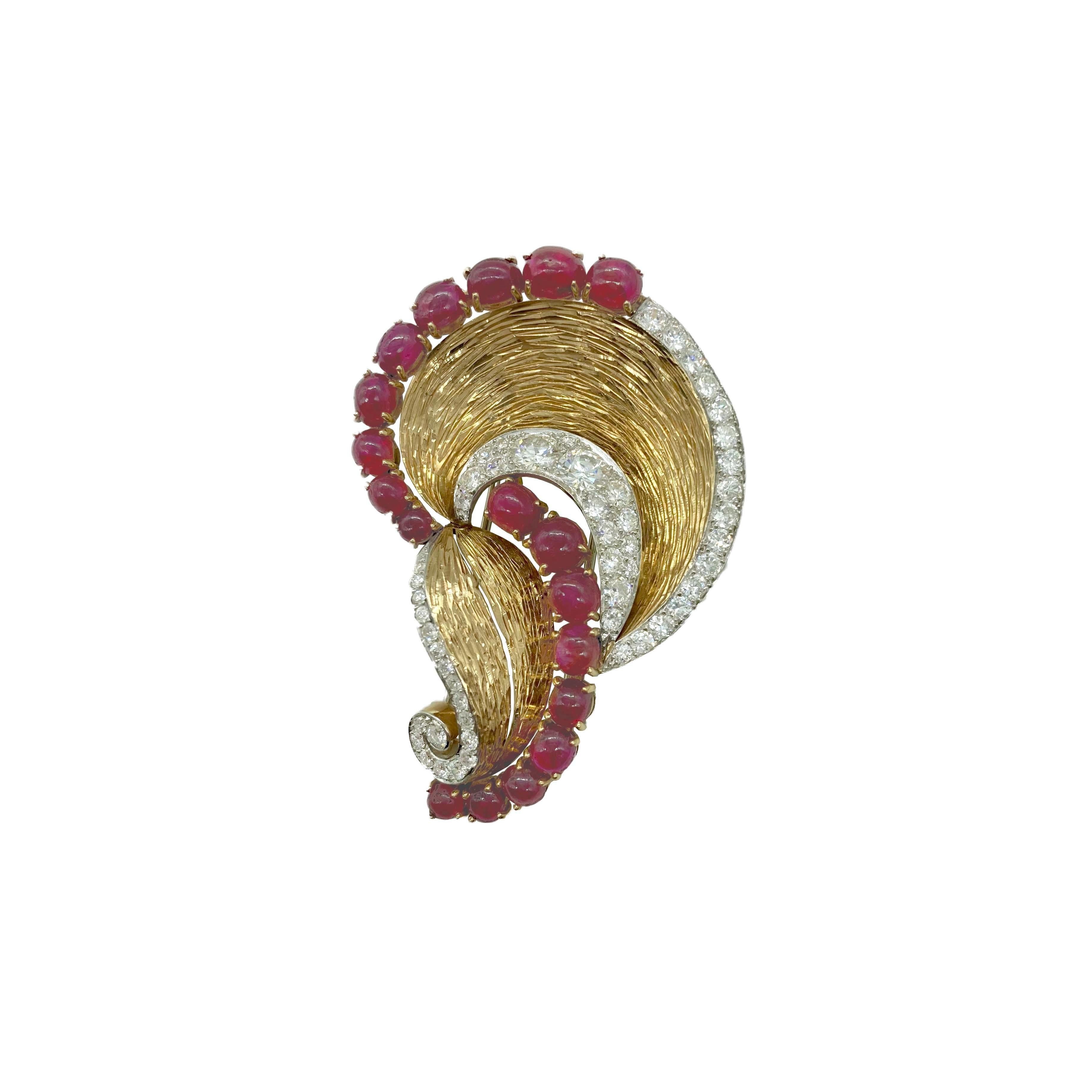 A chic Trabert & Hoeffer for Mauboussin retro clip brooch in 18 karat gold and platinum with 4 carats of diamonds and 18 cabochon rubies totaling 12 carats. Weighs 25.20 grams 