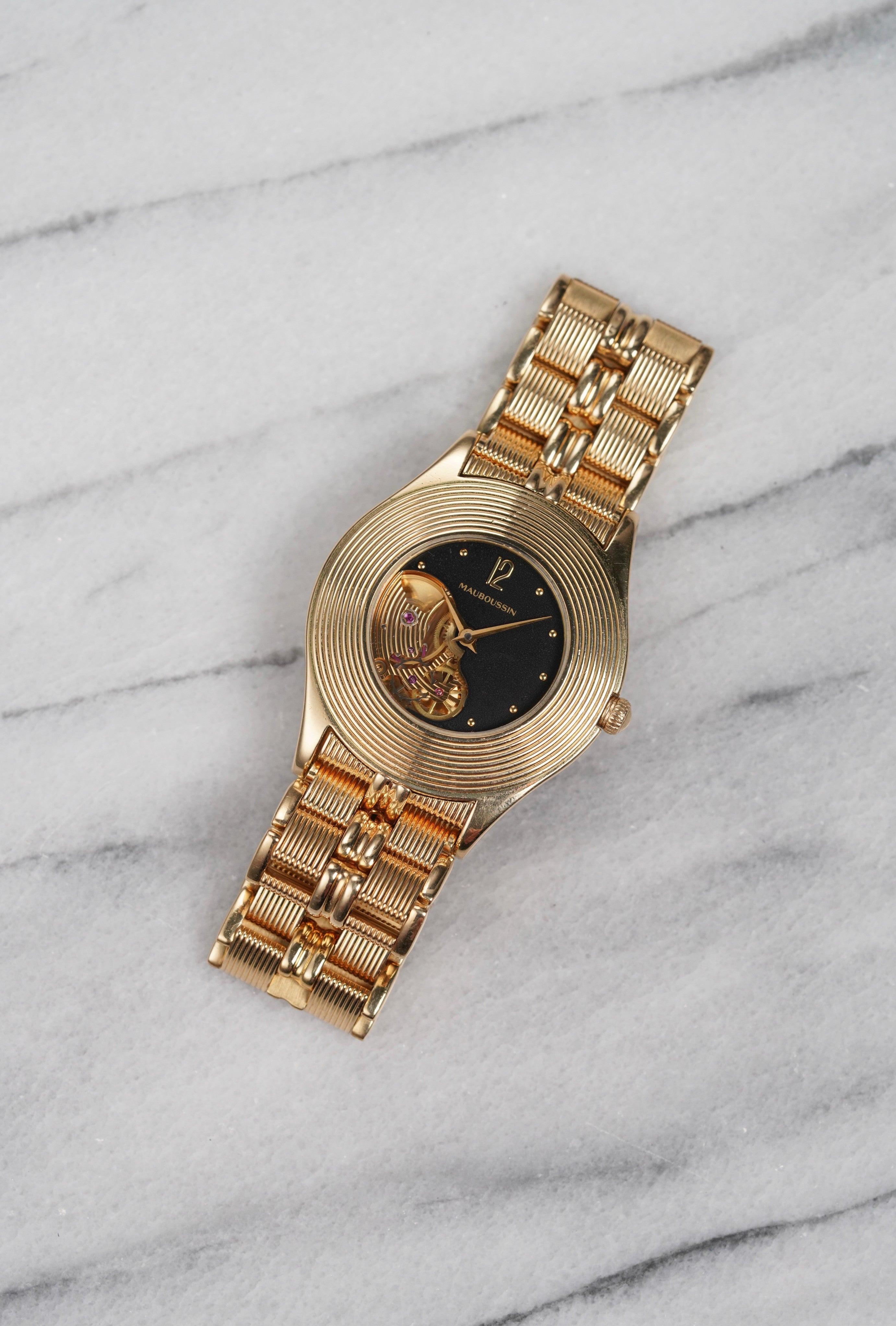 Aquí tienes un Mauboussin de cuerda manual de oro amarillo de 18 quilates con esqueleto negro de la década de 2000, Las medidas son 34x41 mm y 18 mm de ancho de asa. En su brazalete de oro original (con un acabado único y cierre de mariposa). La