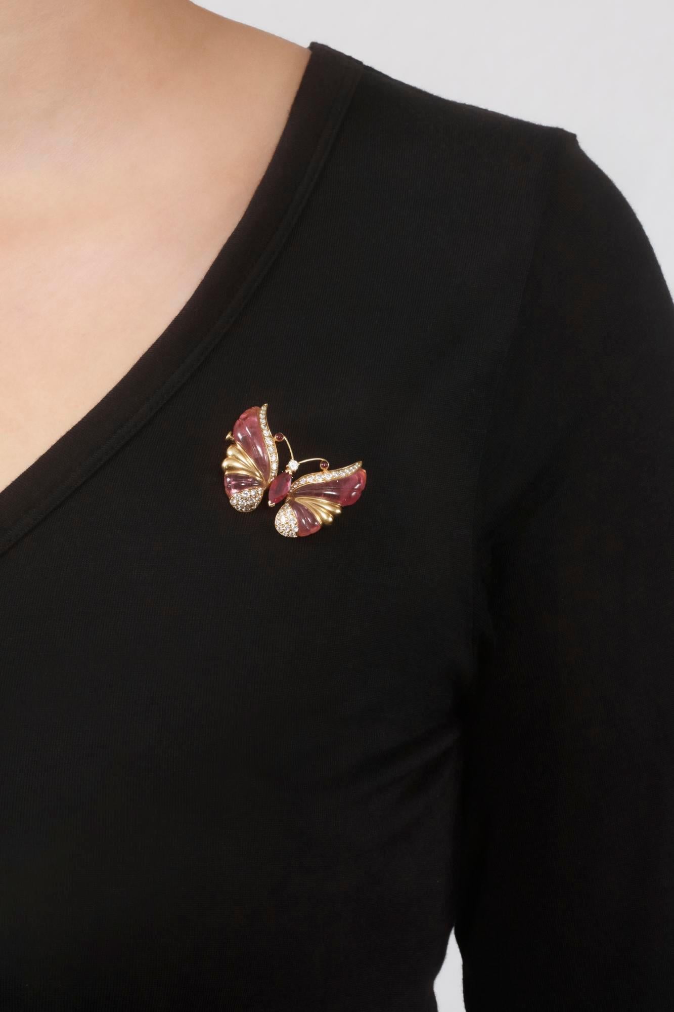 An elegant butterfly brooch set with carved pink tourmaline, marquise-shaped and cabochon rubellite, accented with brilliant-cut diamonds. Signed Mauboussin, numbered, French assay mark for gold and maker's mark.