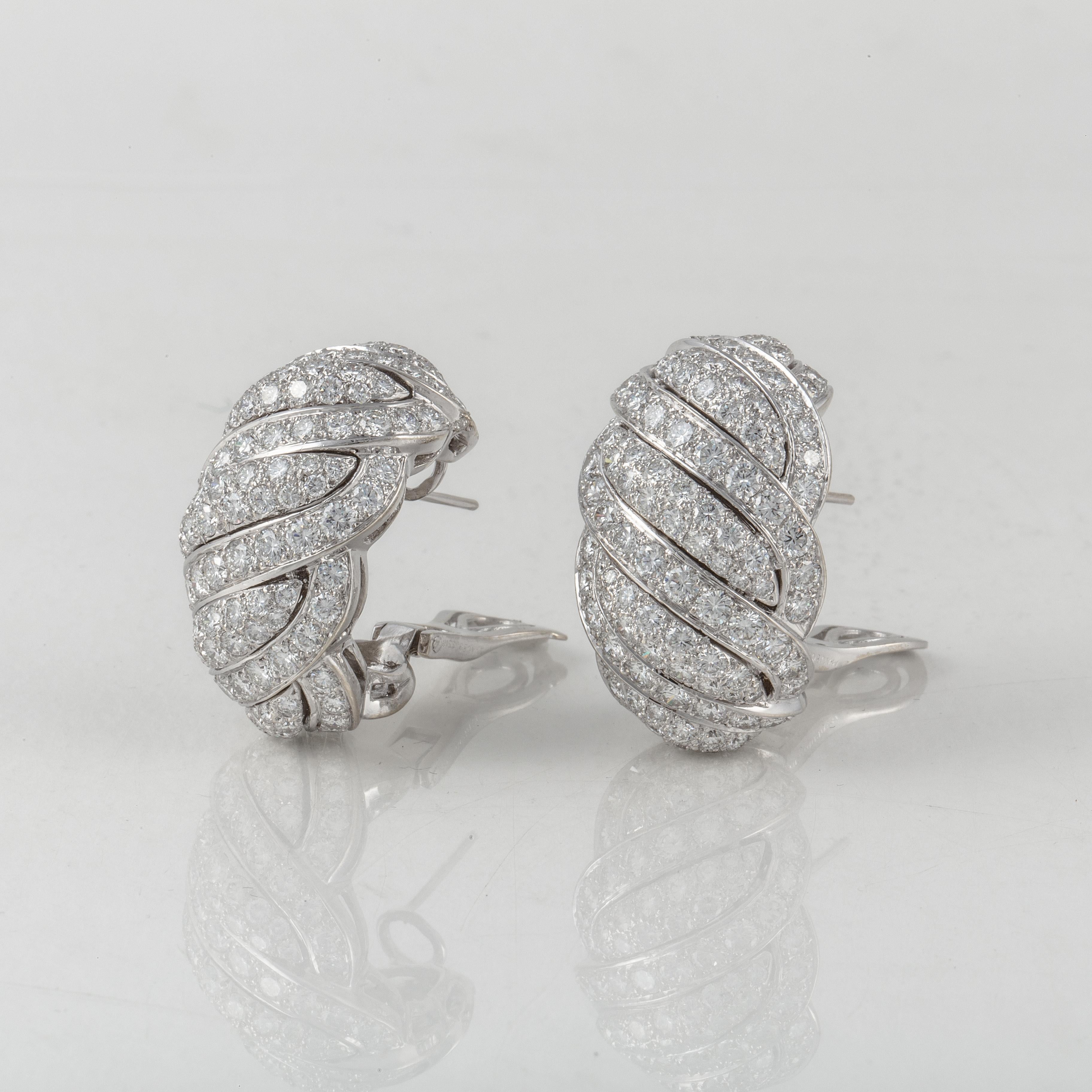 18K white gold diamond earrings by Mauboussin Paris.  They are a half hoop style in a ridged pattern.  There are 246 round diamonds totaling 10 carats, F-G color and VVS1-VS1 clarity.  Measure 1 1/8 inches long, 3/4 inches wide and 3/4 inches deep. 