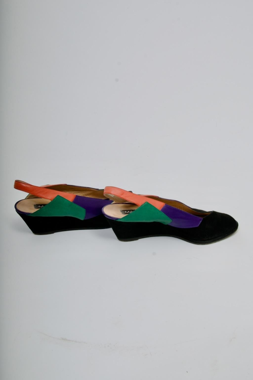 Les chaussures de Maud Frizon ont incarné le style des années 1980, et ces chaussures sont révélatrices de son design créatif. Confectionnées en daim noir, elles présentent un talon compensé, un bout ouvert et une empeigne en forme de V. L'intérêt